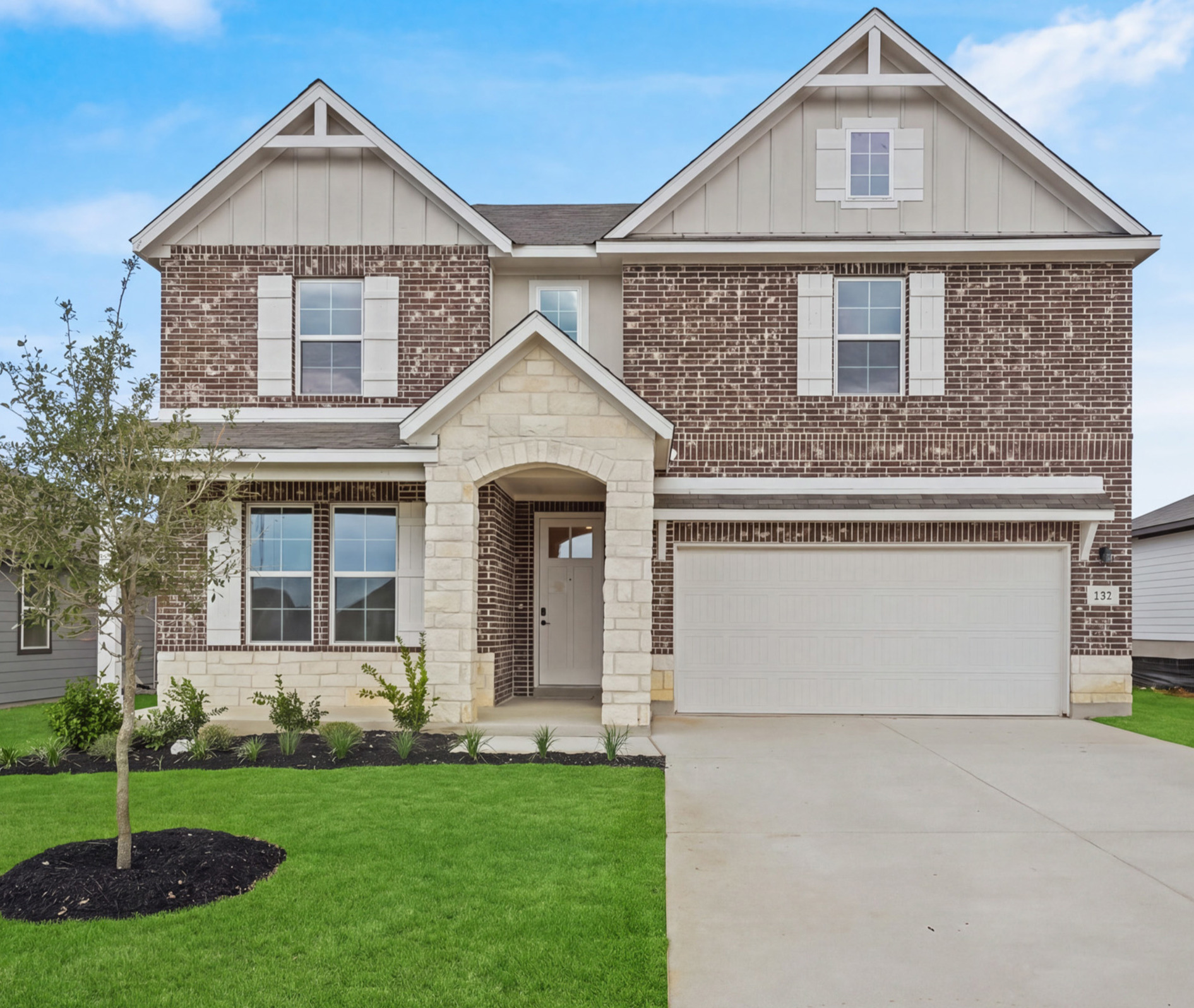home with brick, windows and landscaped grass