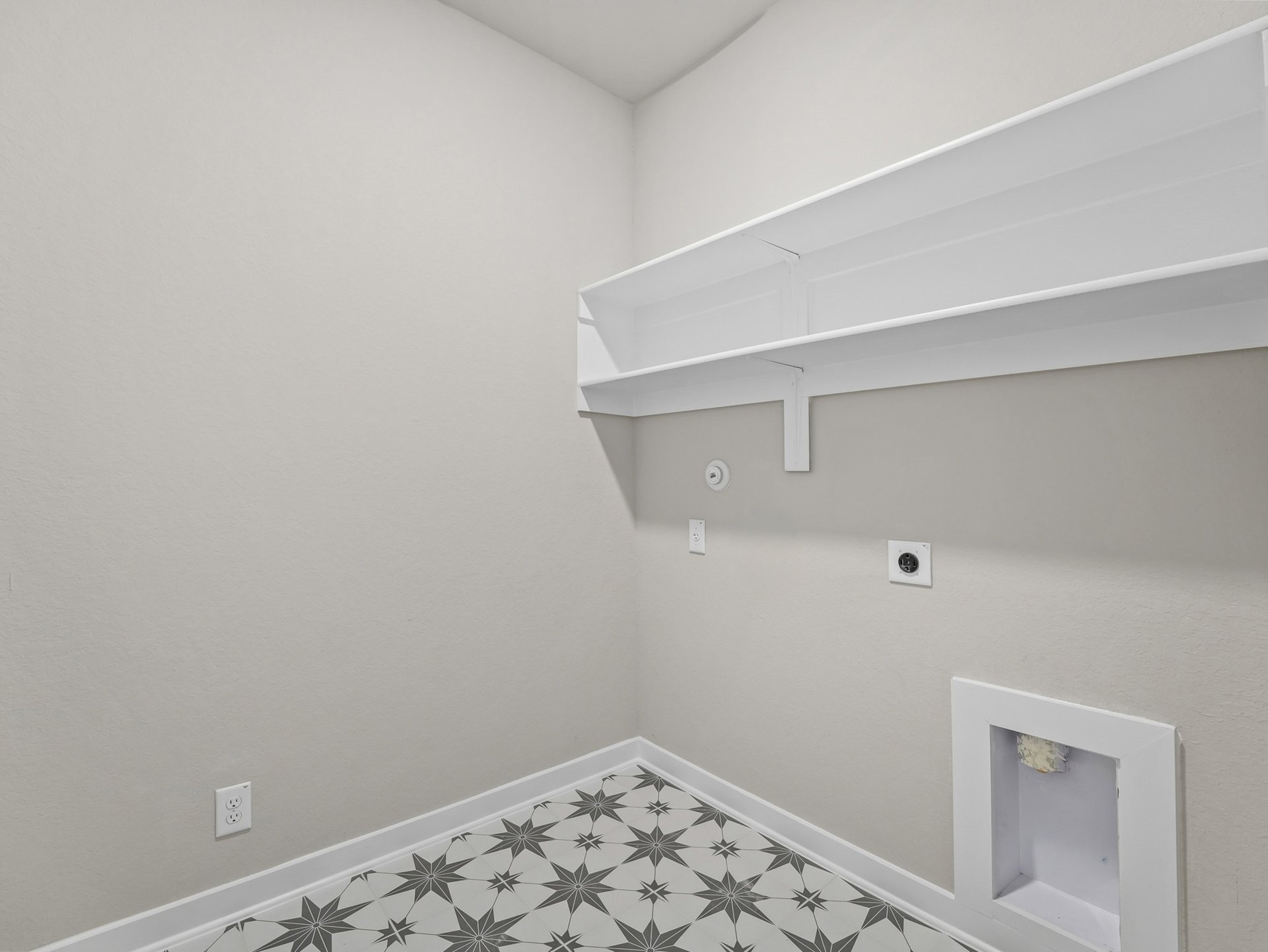 laundry room with patterned floor and storage space