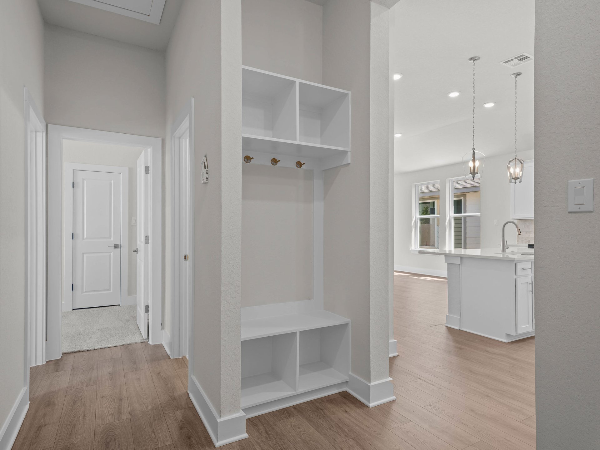 foyer with brown flooring and white cabinets