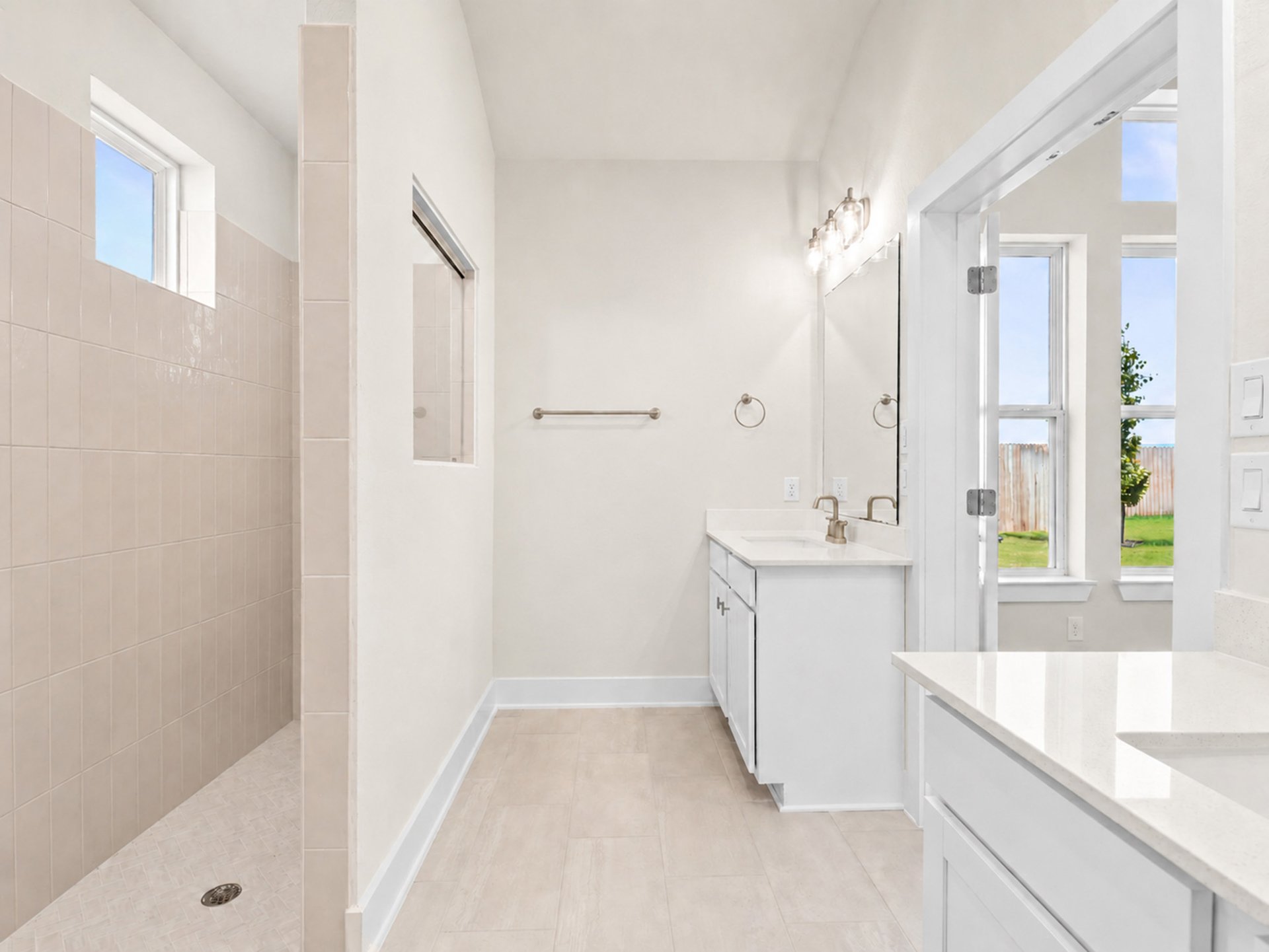 primary bathroom with walk-in shower and dual sinks