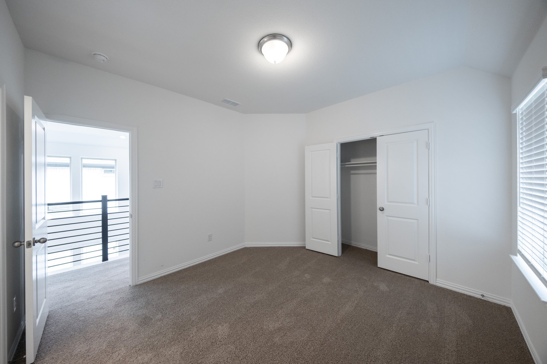 guest bedroom with carpet and window