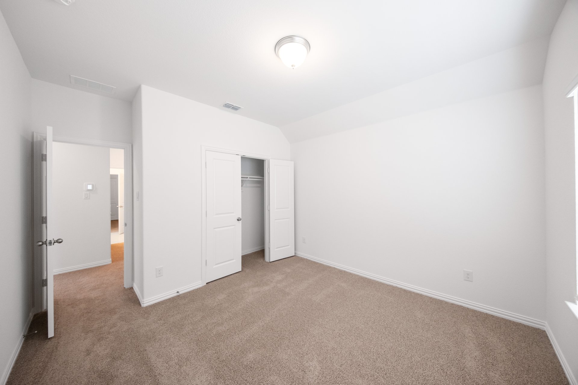 guest bedroom with carpet and window
