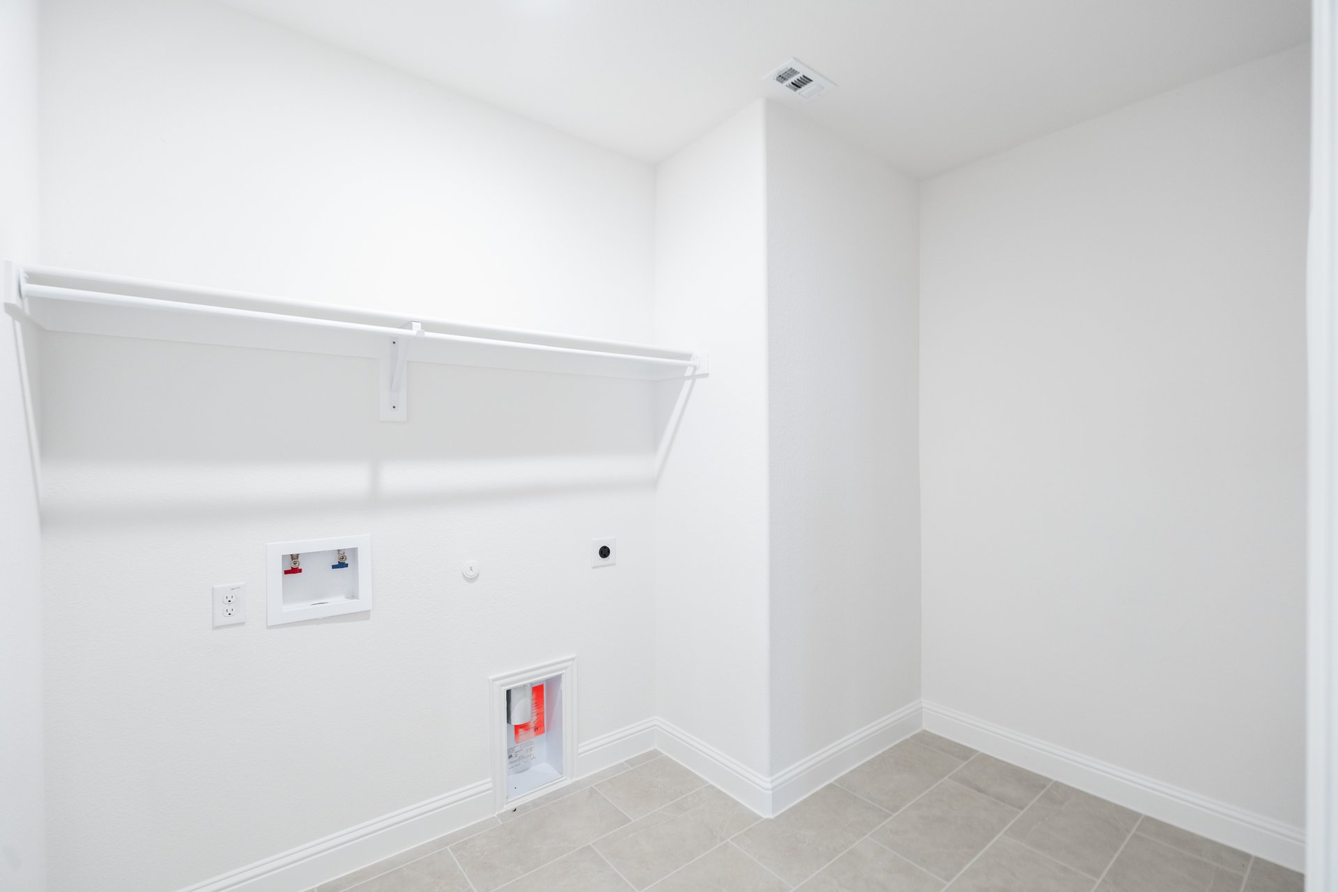 laundry room with tile and hanging racks