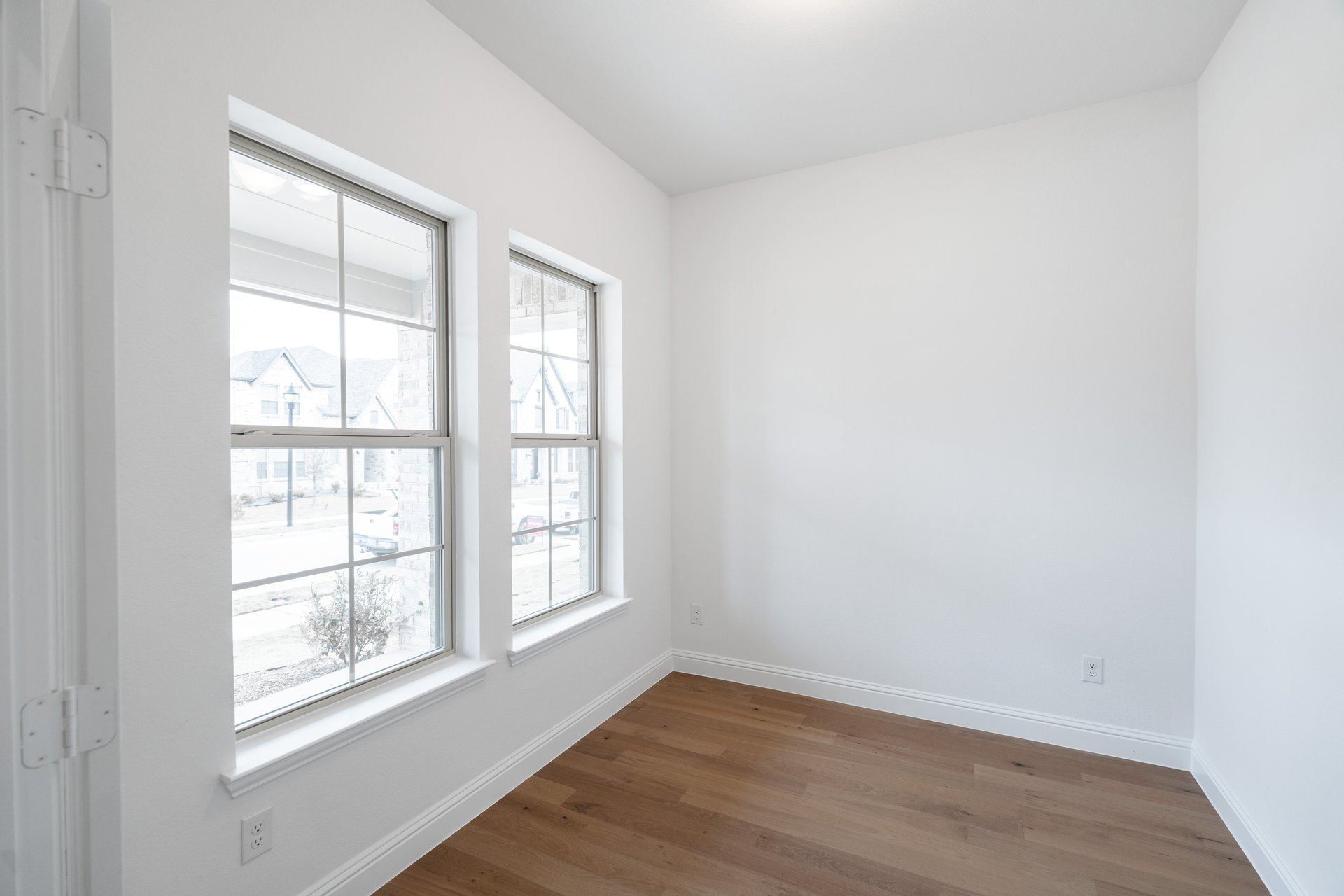 study with large windows and wood flooring