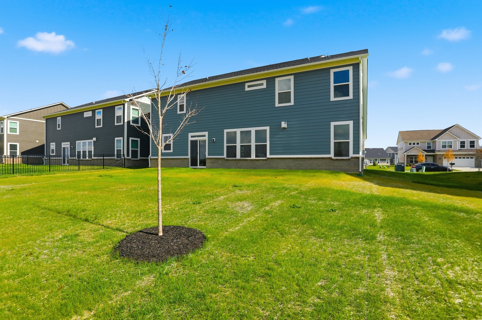 back exterior of home with green grass and blue siding