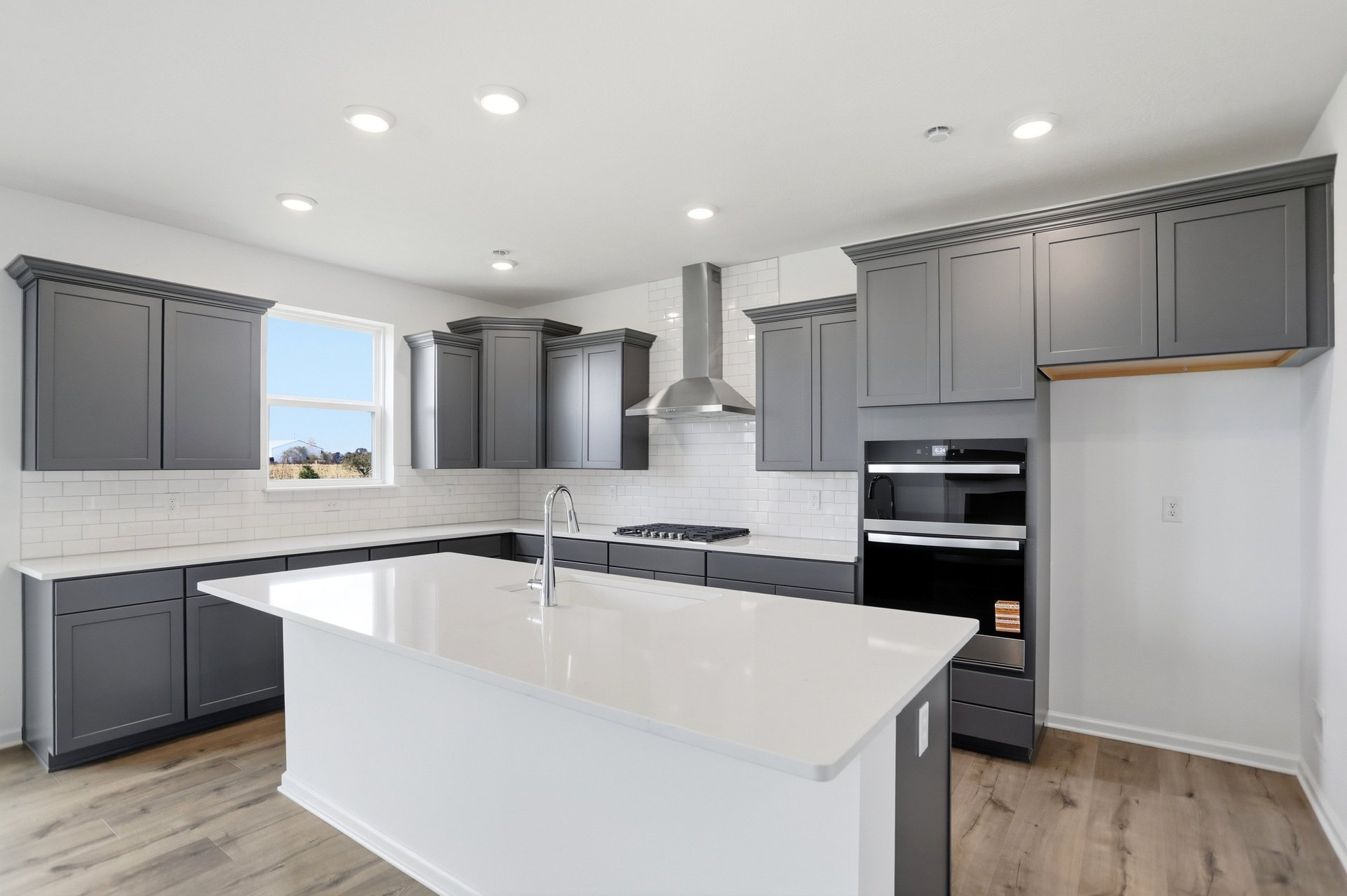kitchen with dark gray cabinets and a large kitchen island with white counters