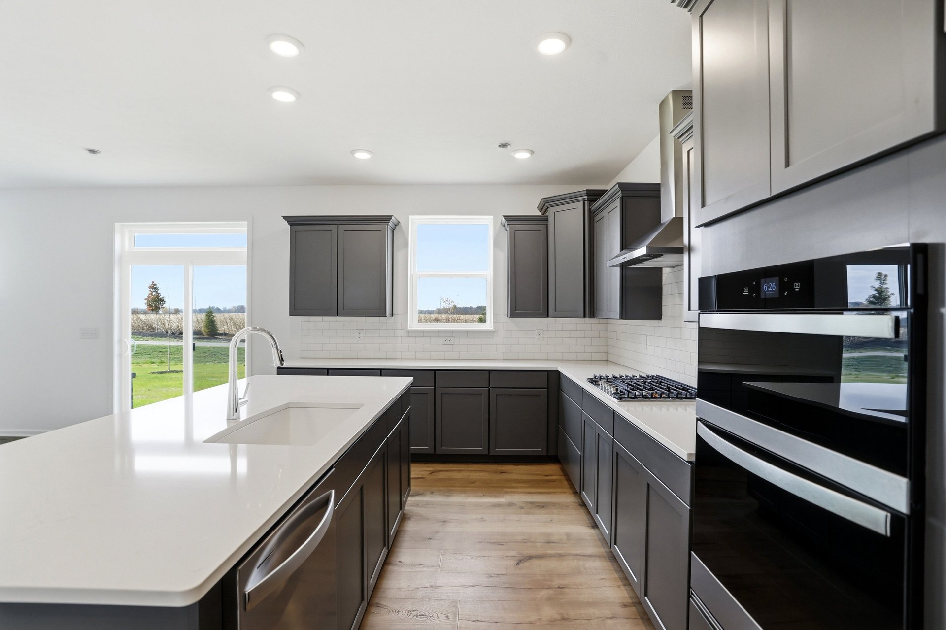 kitchen with dark gray cabinets and a white tile backsplash