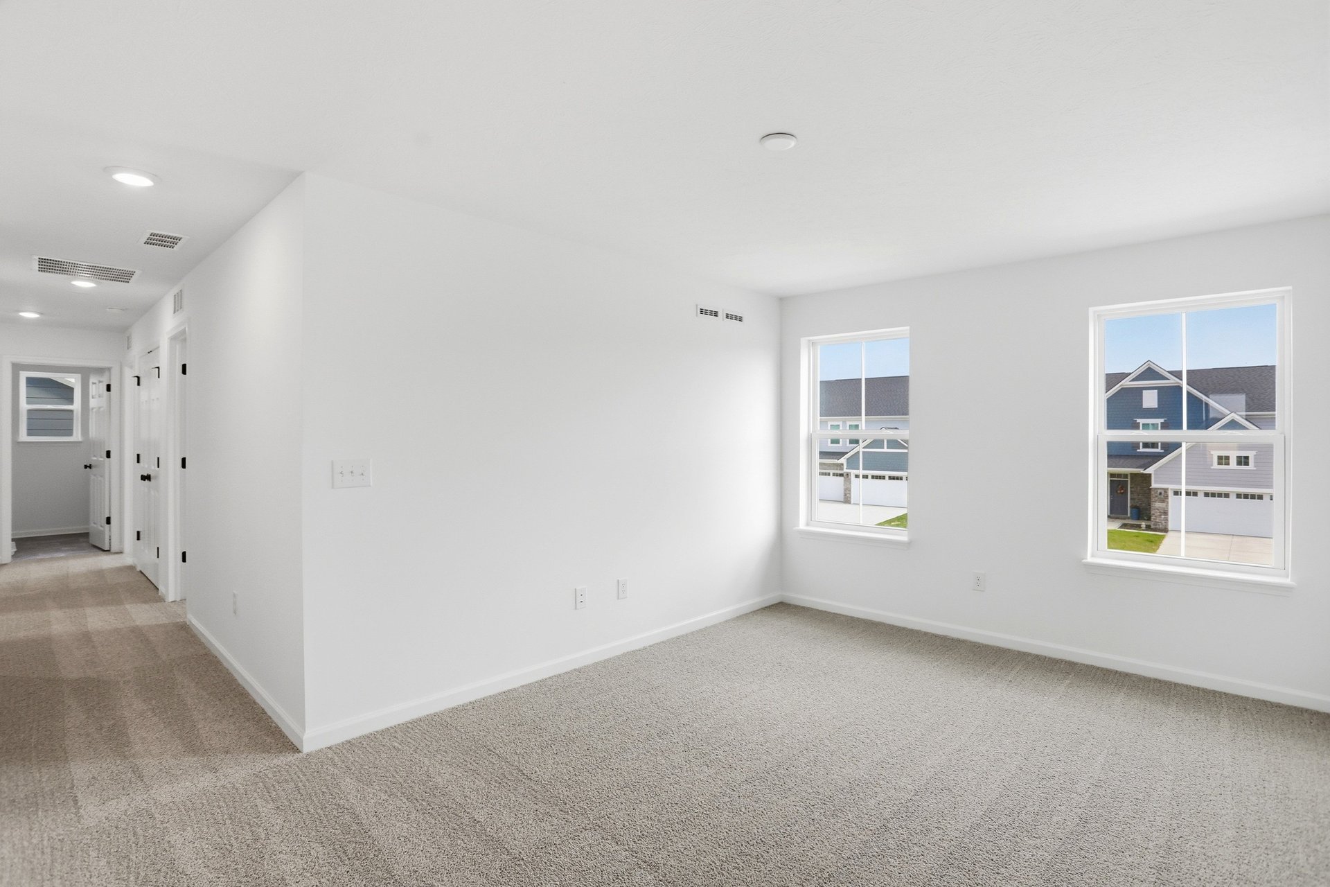 loft with gray carpets and windows letting in natural light