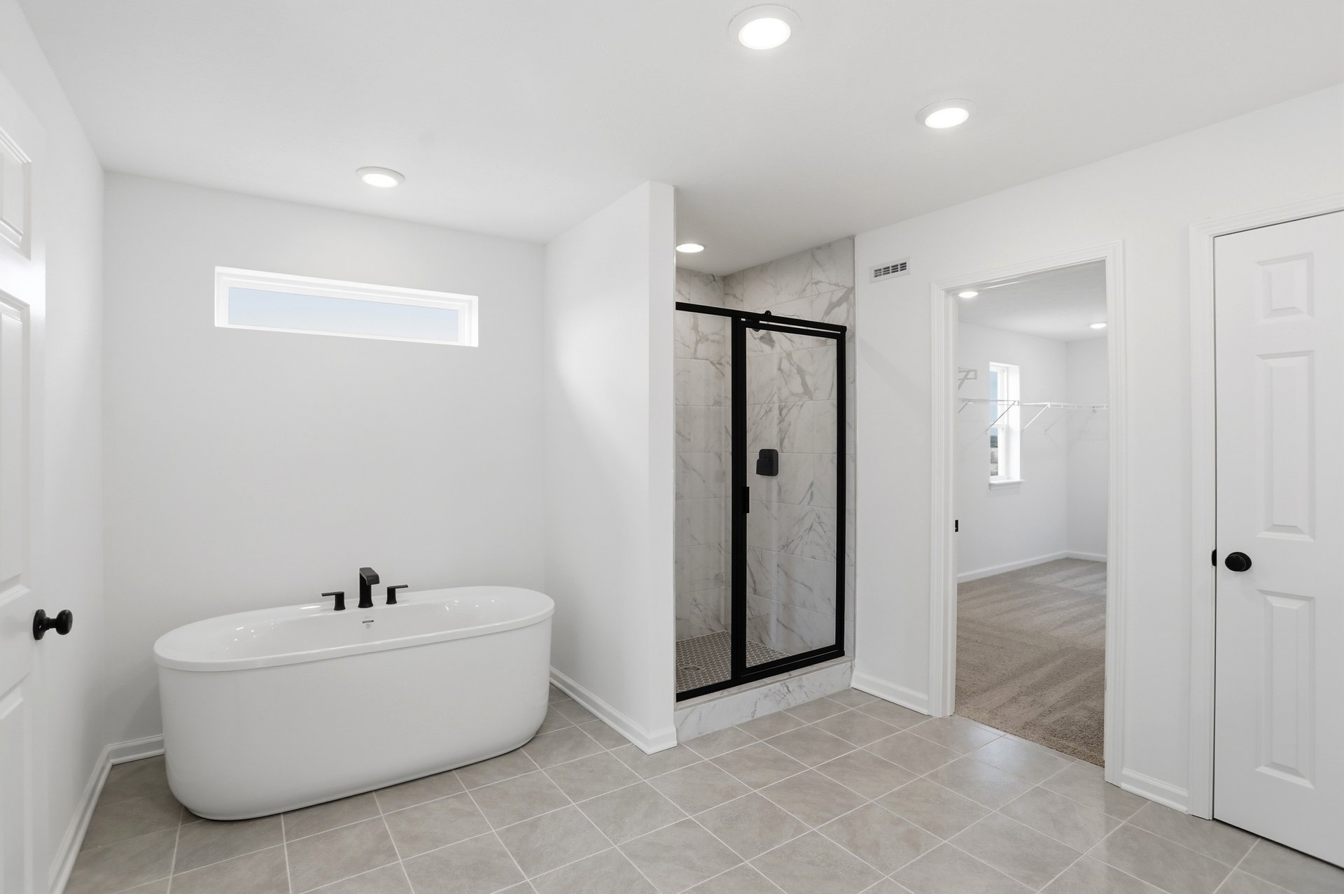 bathroom with white soaking tub and a tile walk-in shower