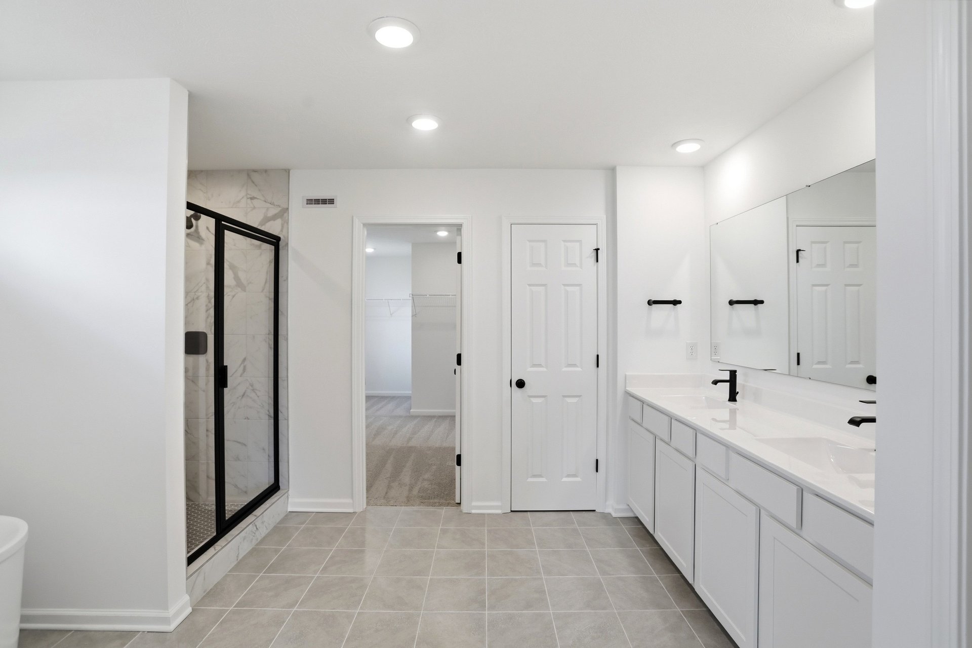 bathroom with gray tile flooring and a walk-in shower