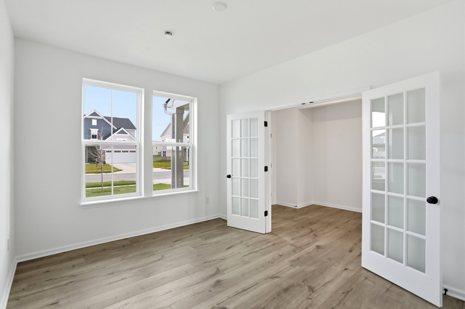 study with wood plank flooring and double french doors