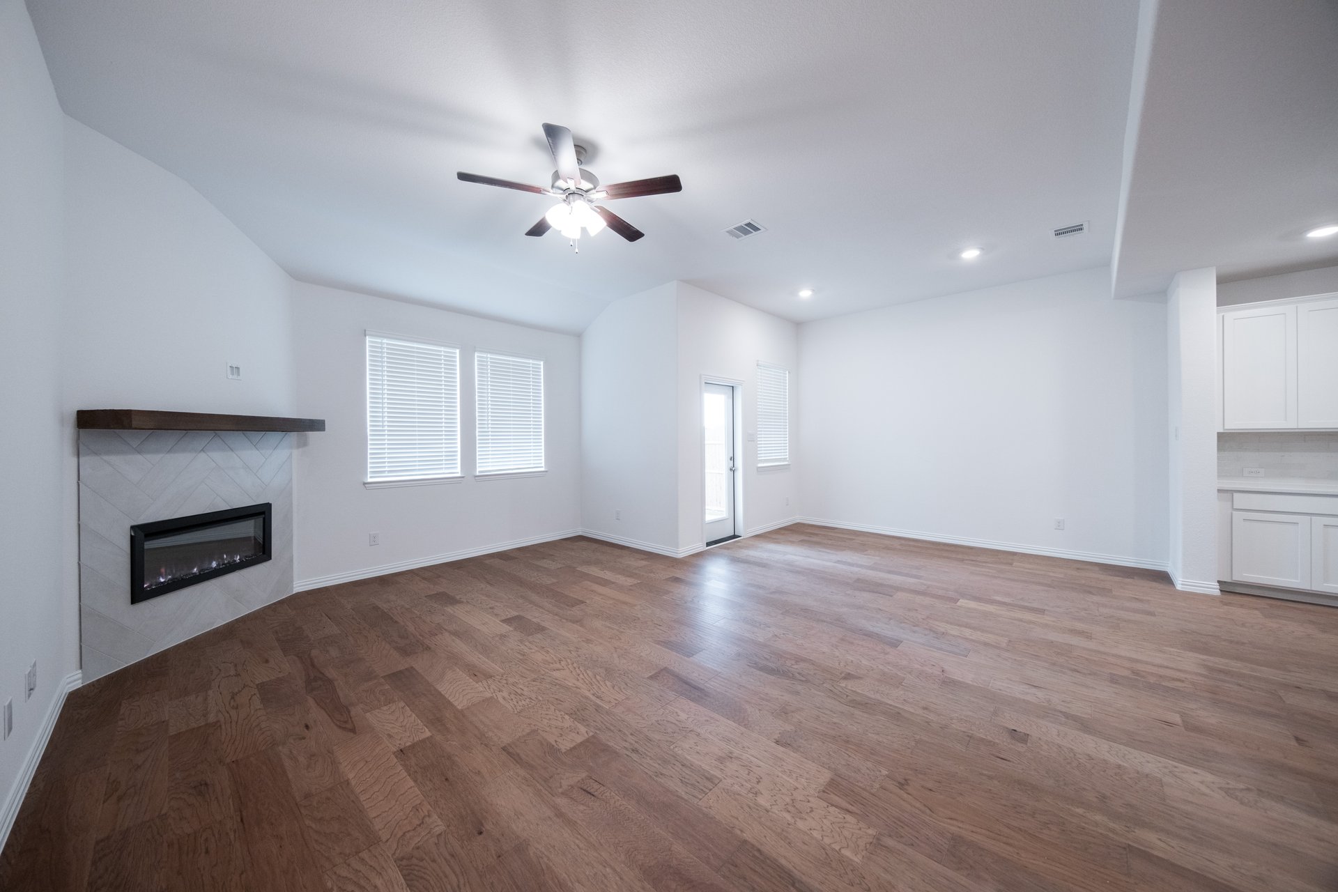 open great room with wood floors and fireplace