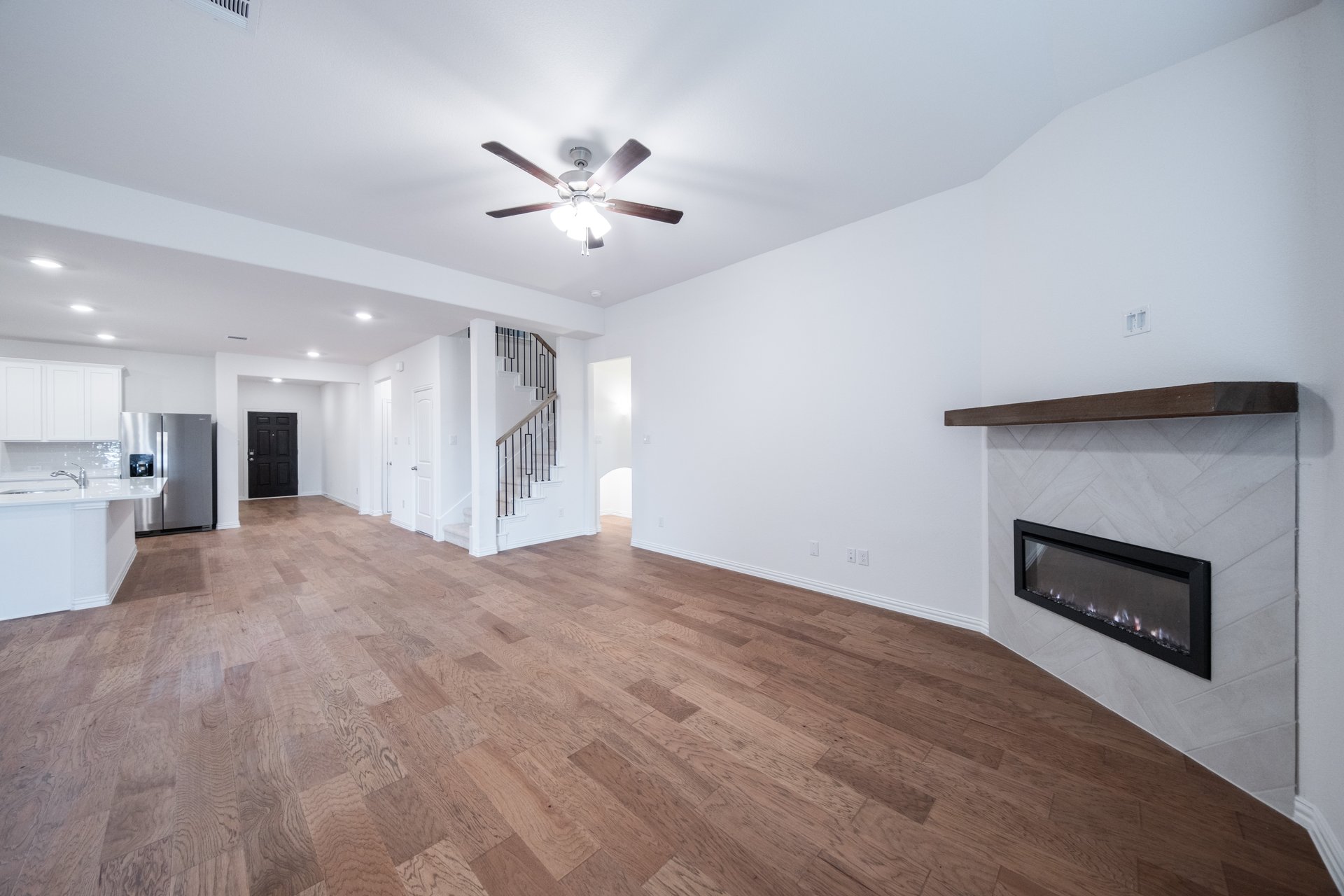 open great room with wood floors and fireplace