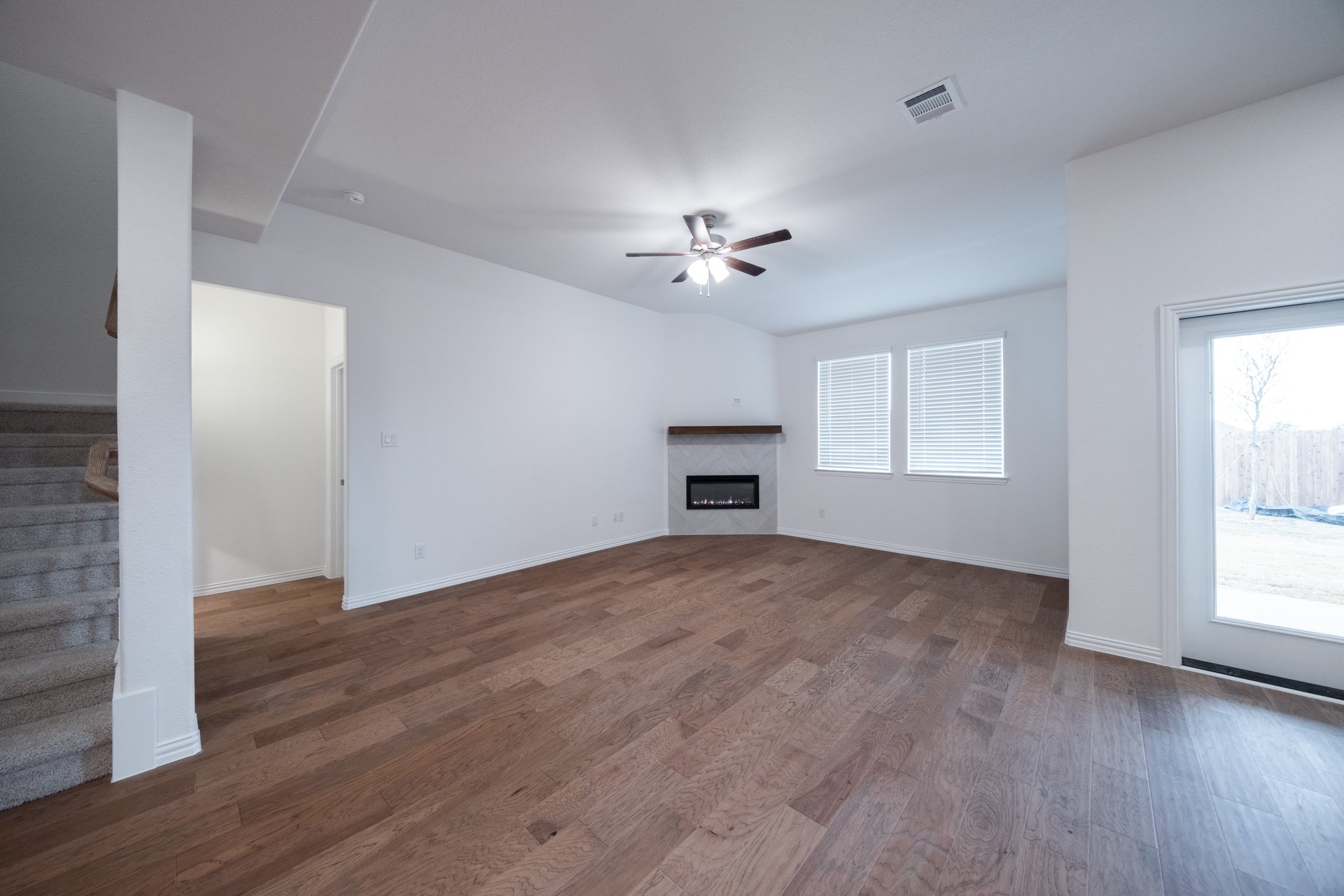 open great room with wood floors and fireplace