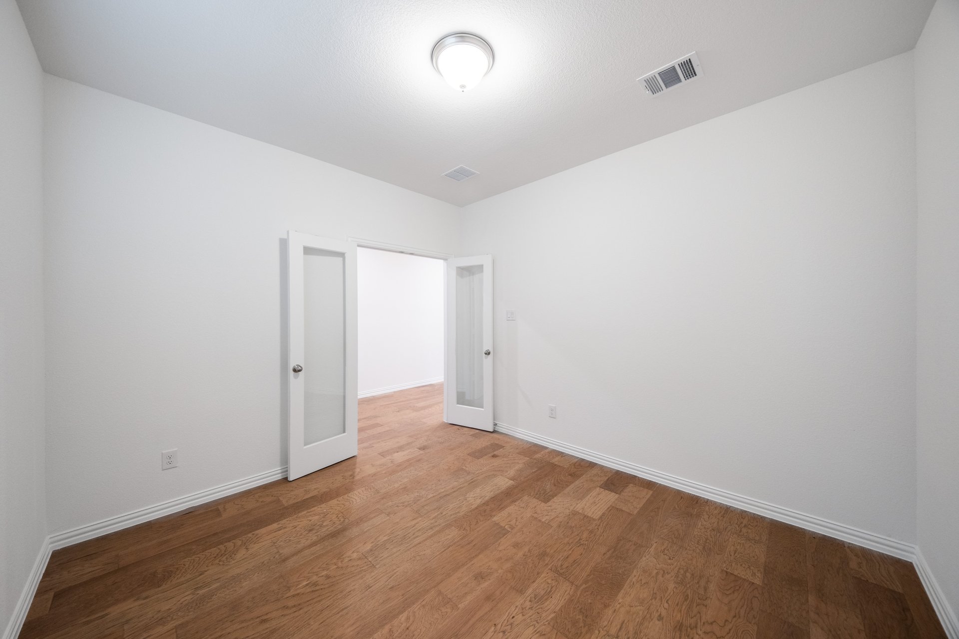 private study with wood floors and french doors