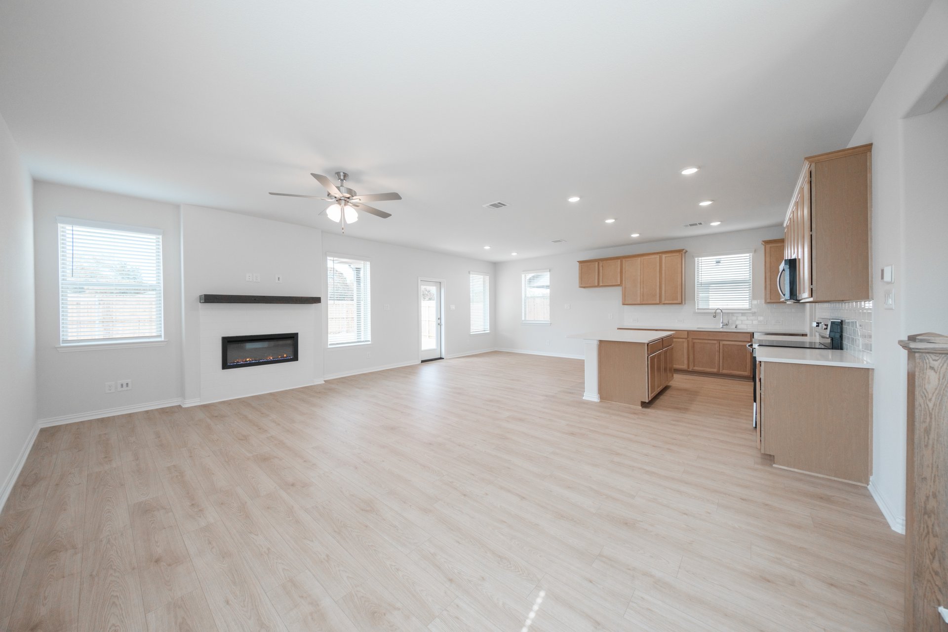 open great room with wood floors and fireplace