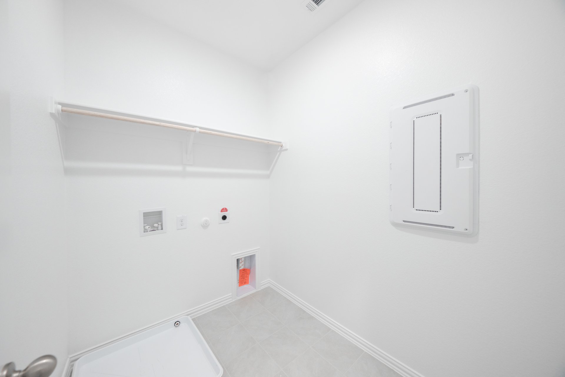 laundry room with tile floors and white shelf