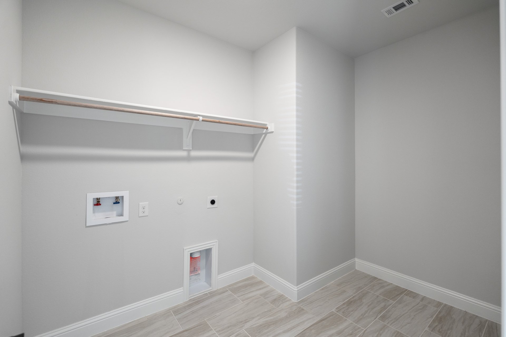 laundry room with tile floors and white shelf