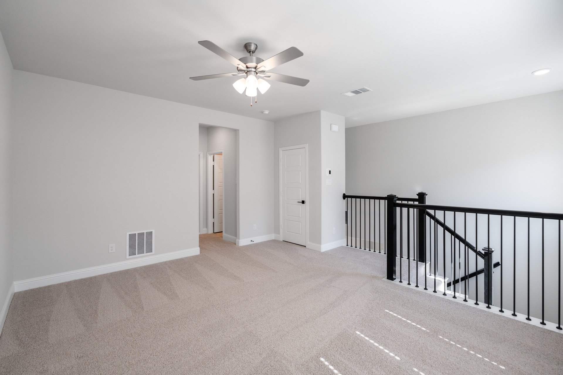 open loft with carpet and ceiling fan