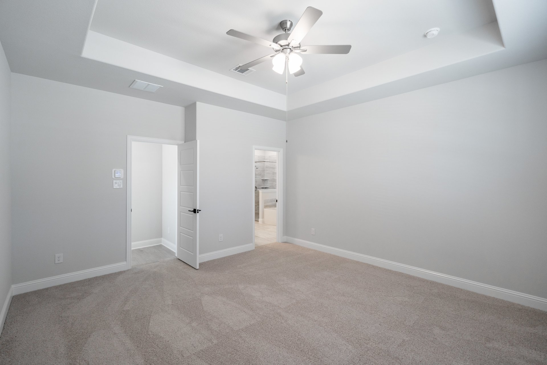 primary bedroom with carpet and ceiling fan