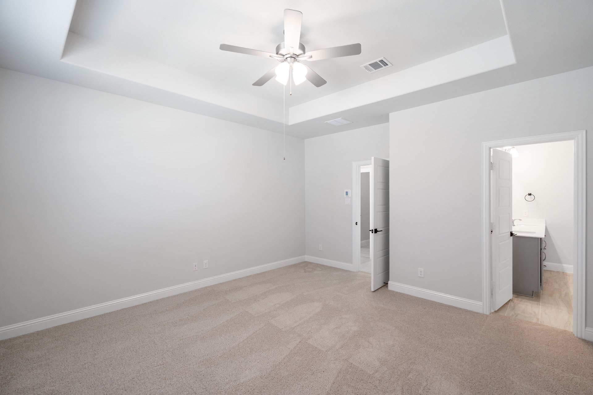 primary bedroom with carpet and ceiling fan