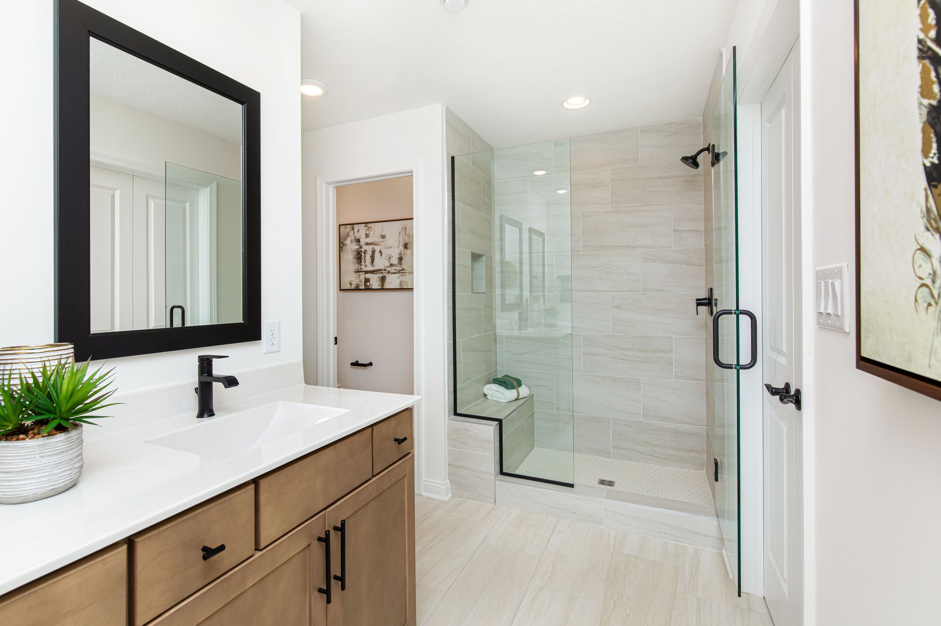 bathroom with tile walk-in shower and a brown wood vanity