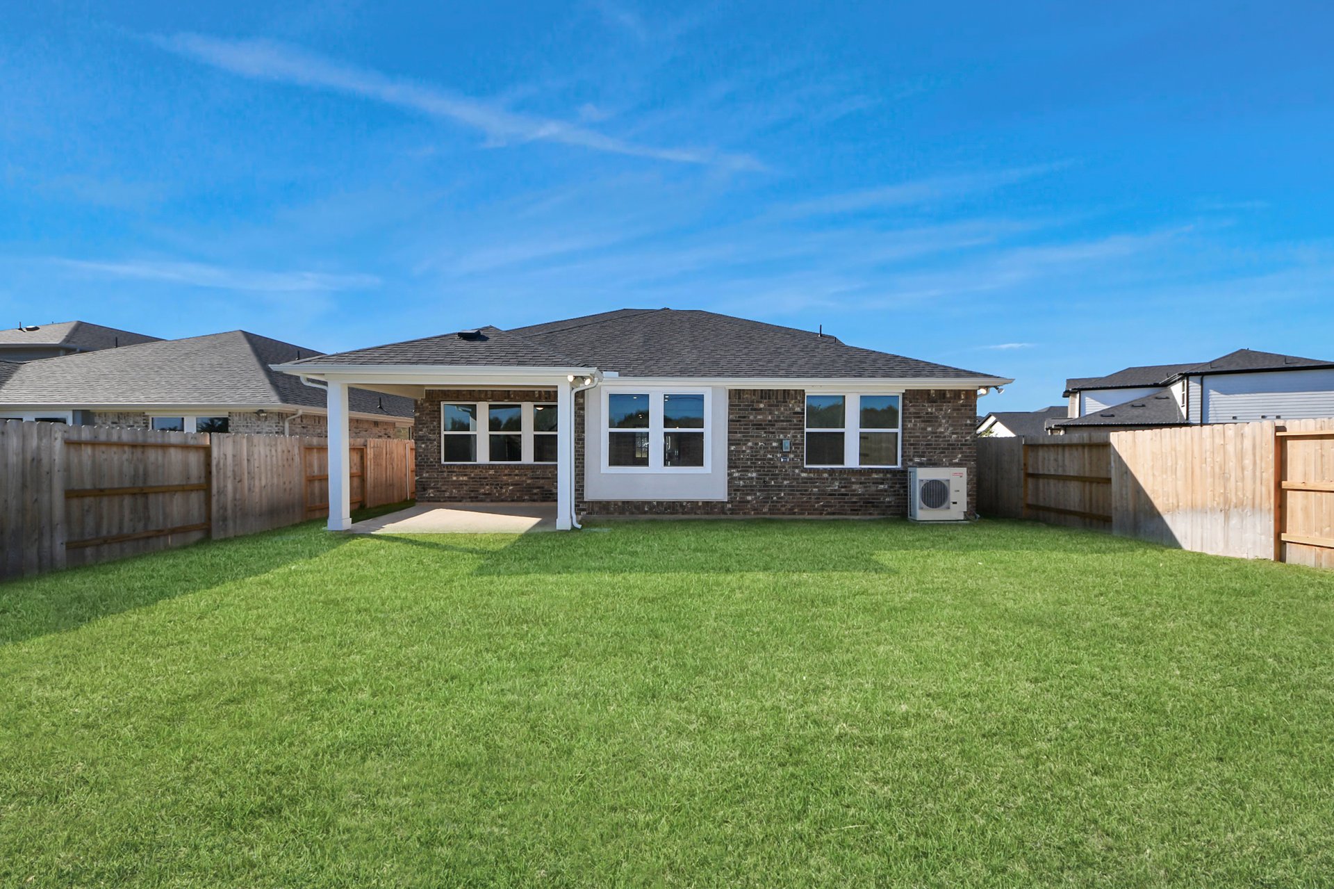 Large backyard with greenery.