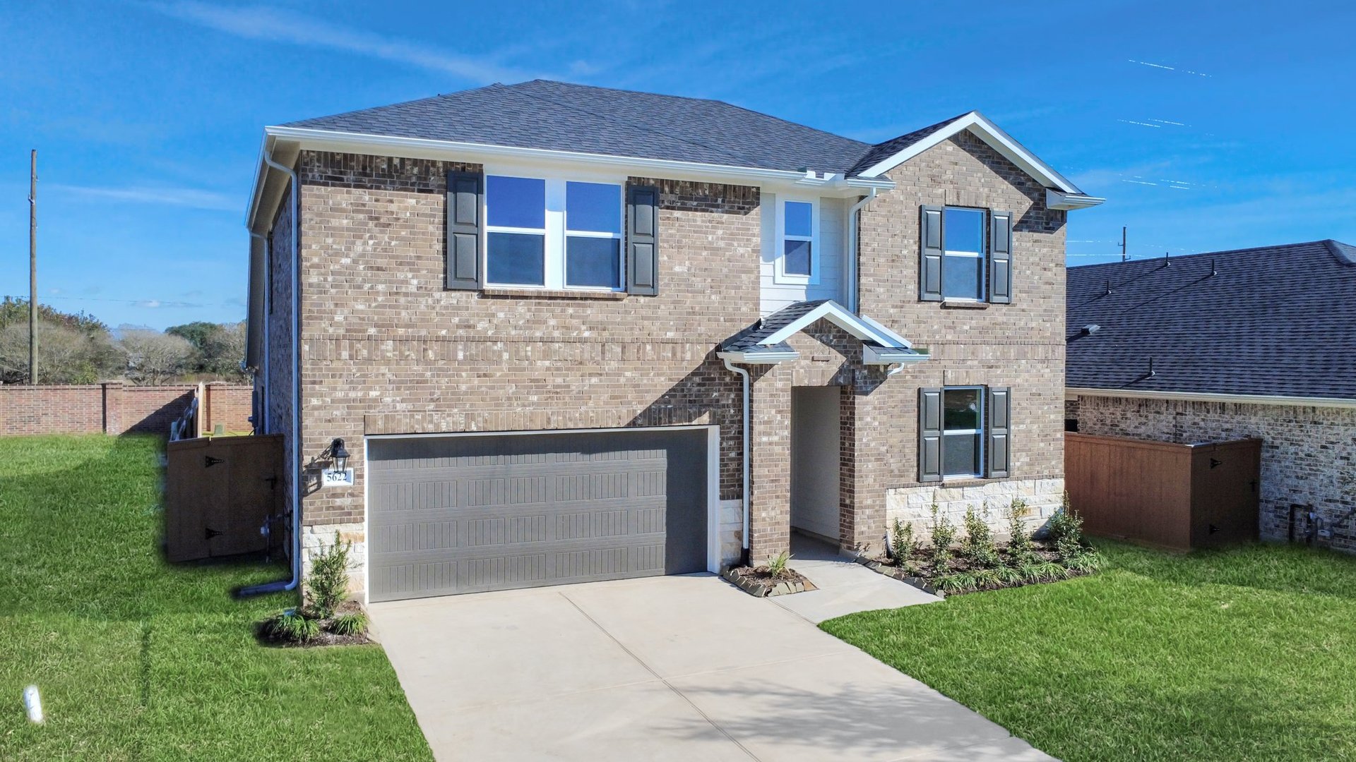 Two-story home with brick and a brown garage door.