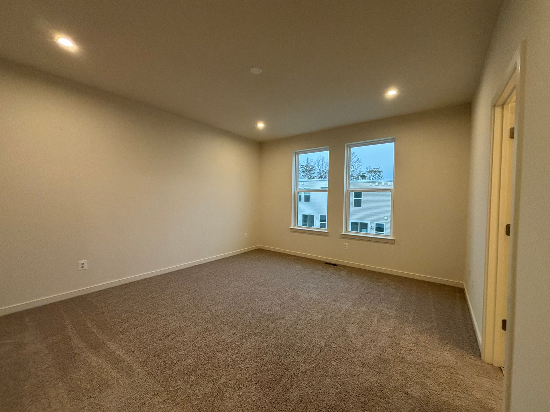primary bedroom with two windows and access to bathroom