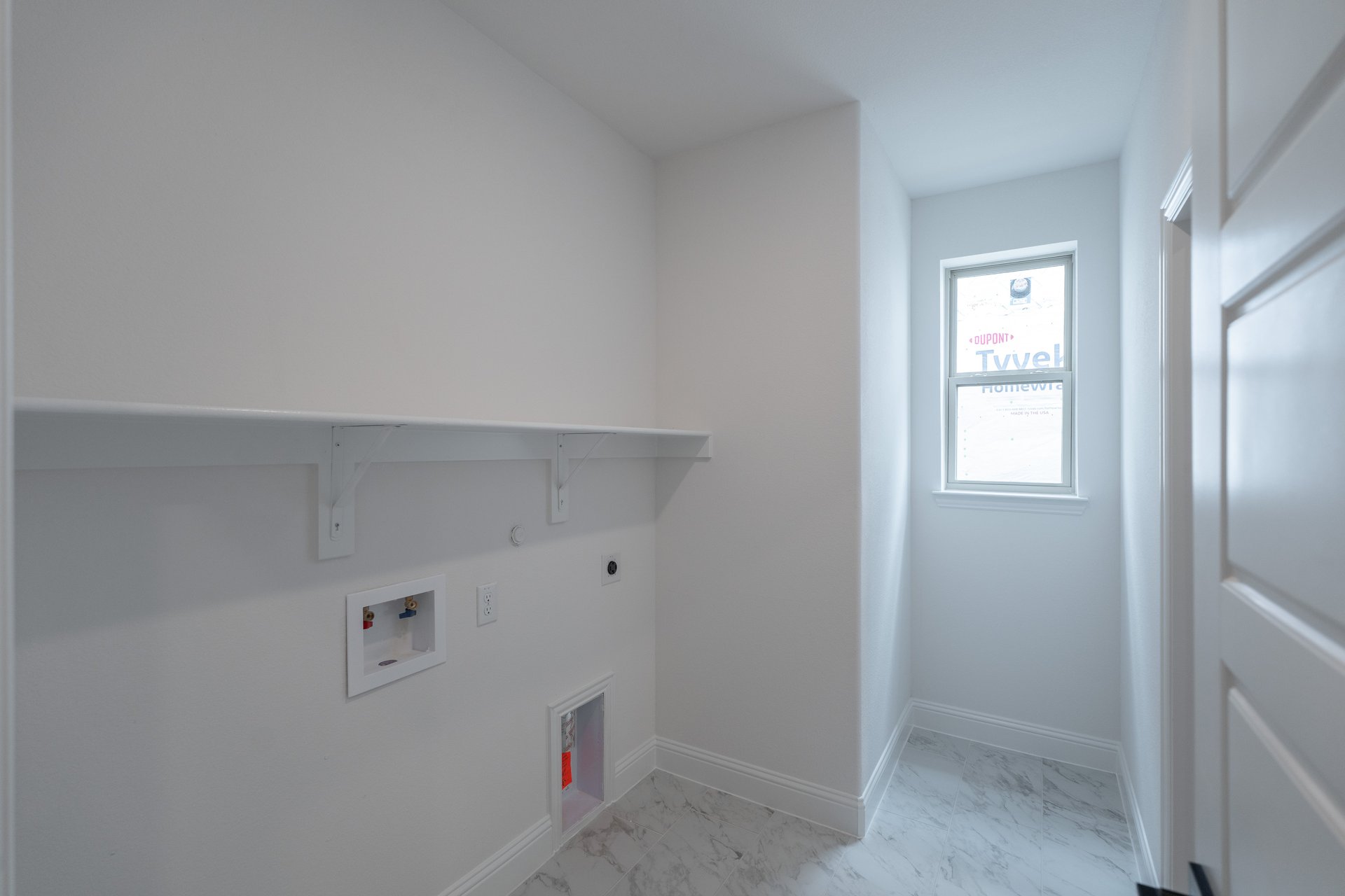 laundry room with tile floors and white shelf