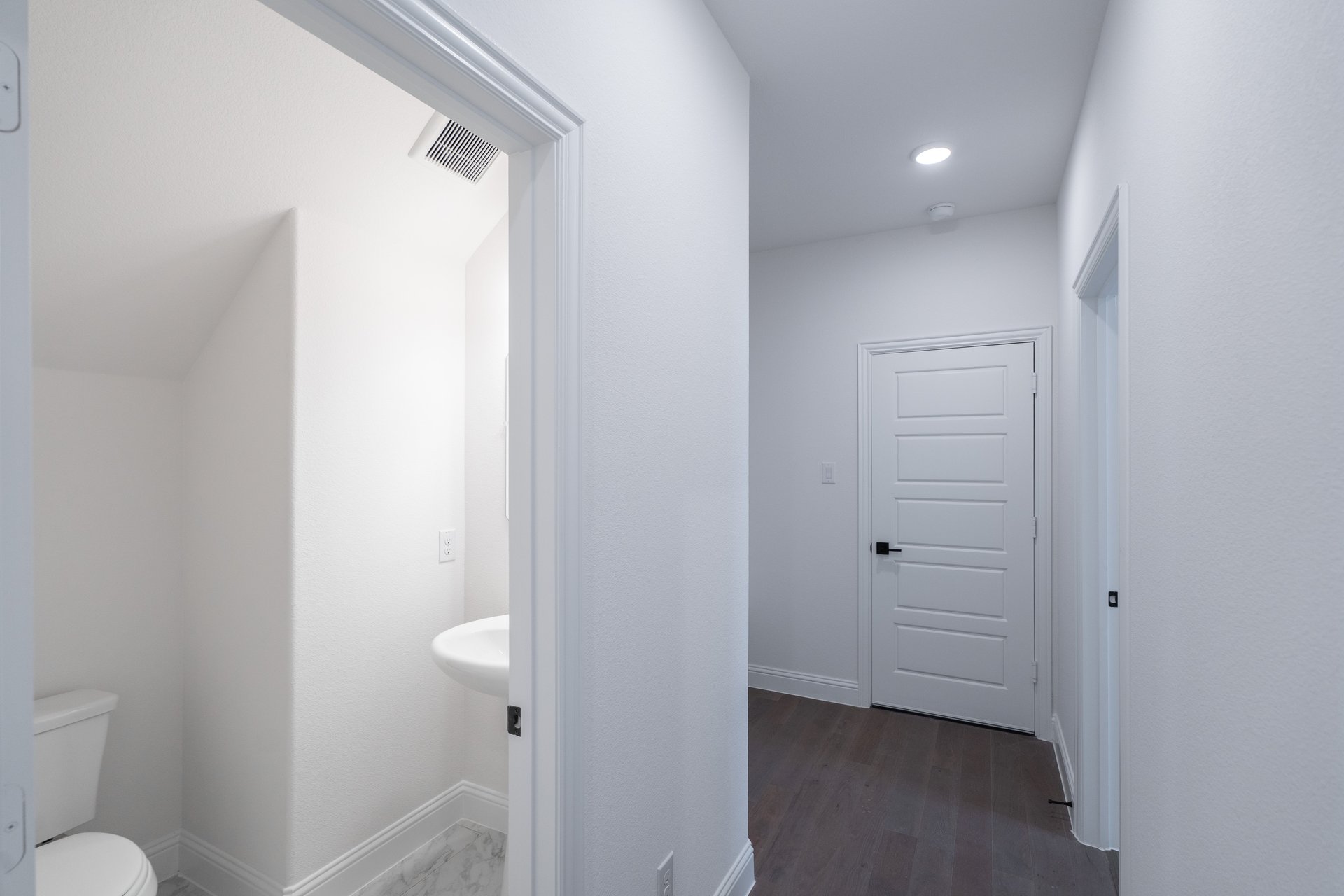 mudroom with wood floors and white shelves with bench
