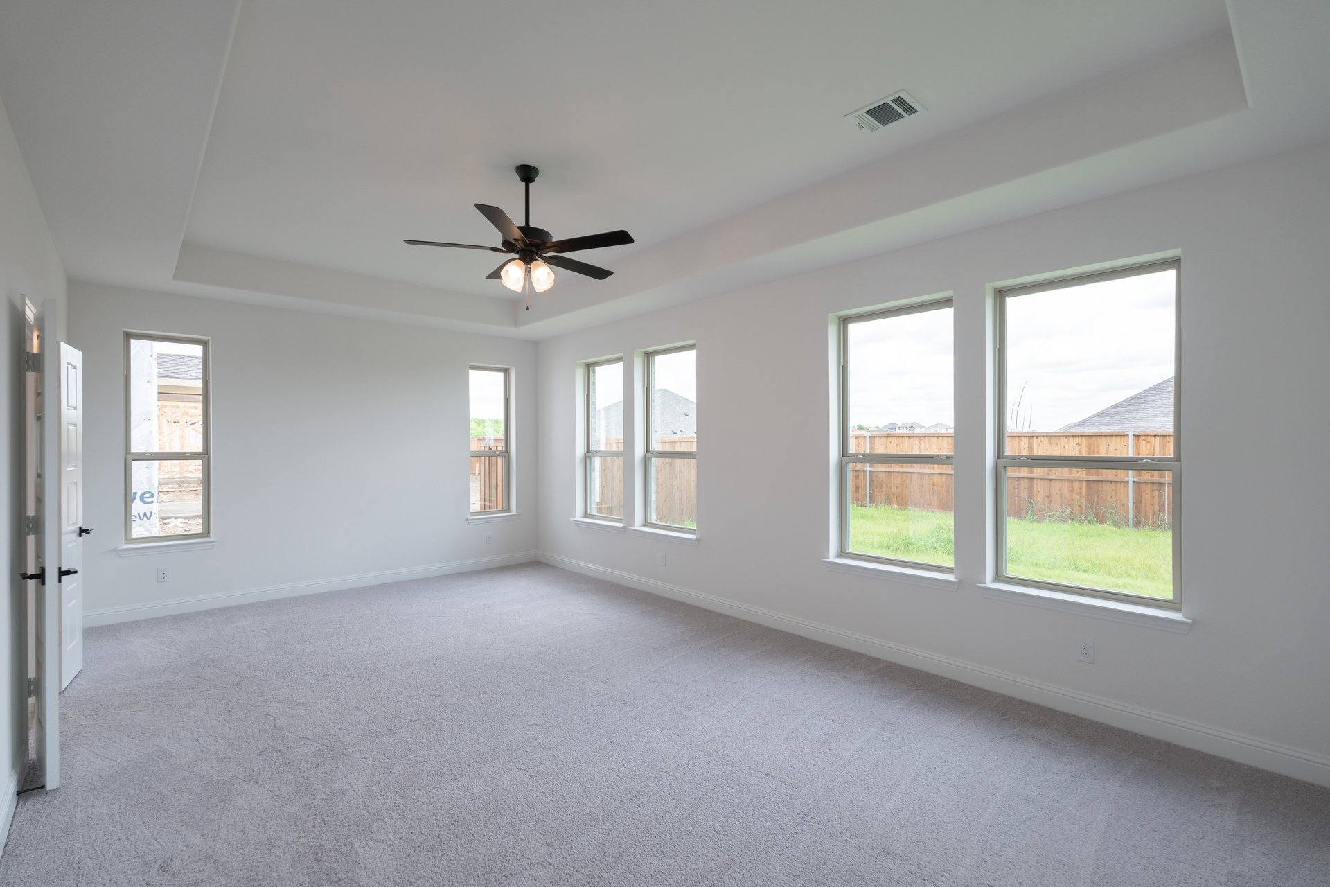 primary bedroom with carpet and ceiling fan