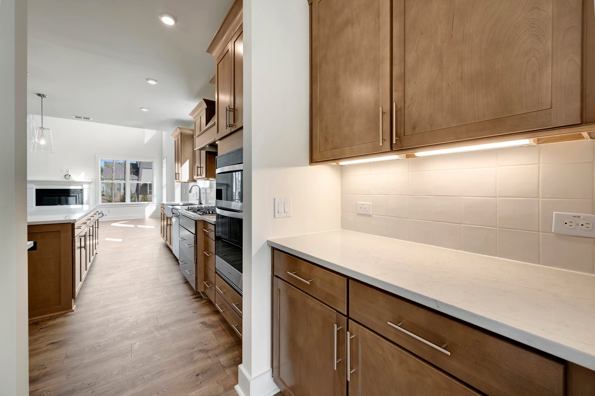 butler's pantry with under cabinet lighting and access to the kitchen