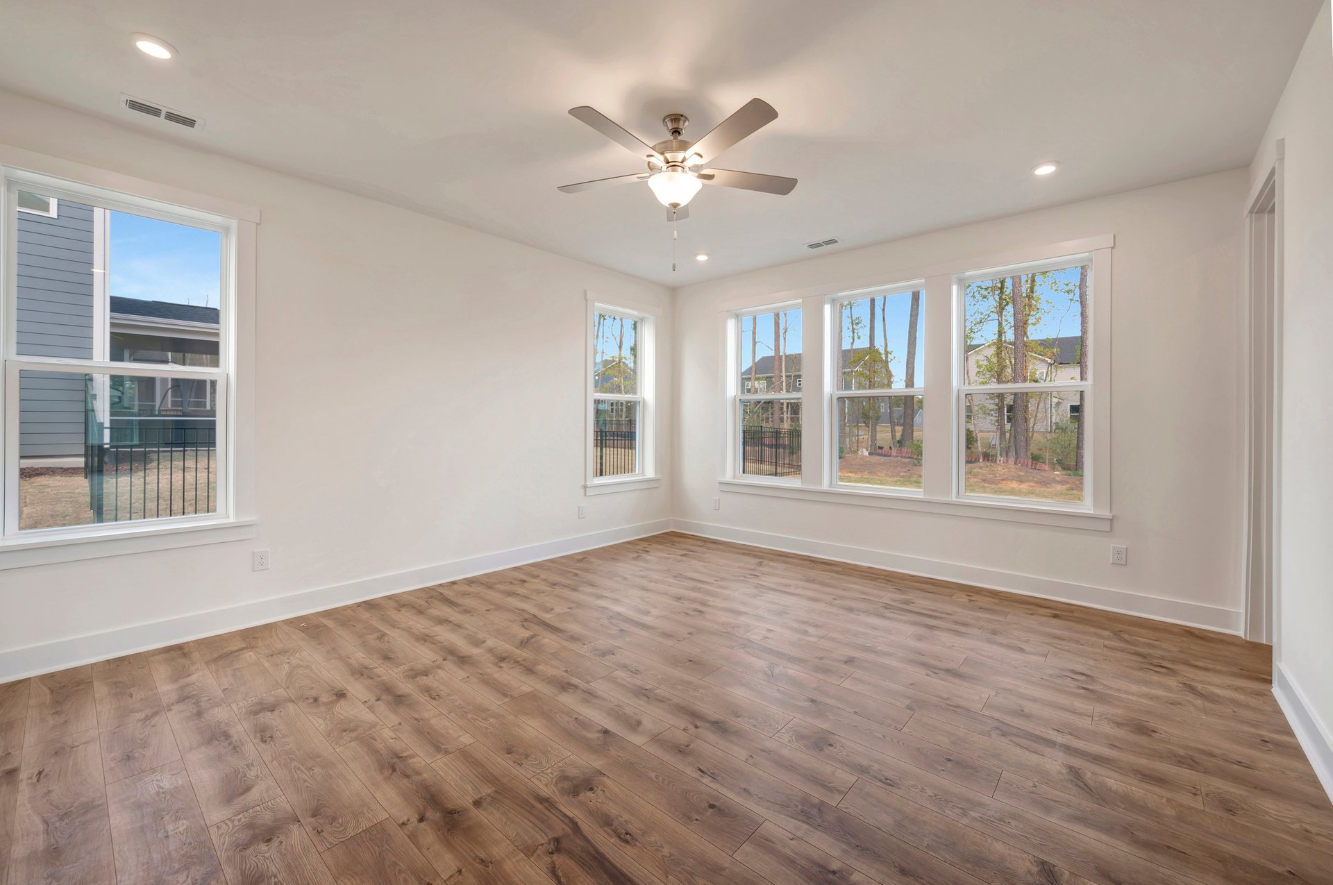 primary bedroom with five windows and a ceiling fan