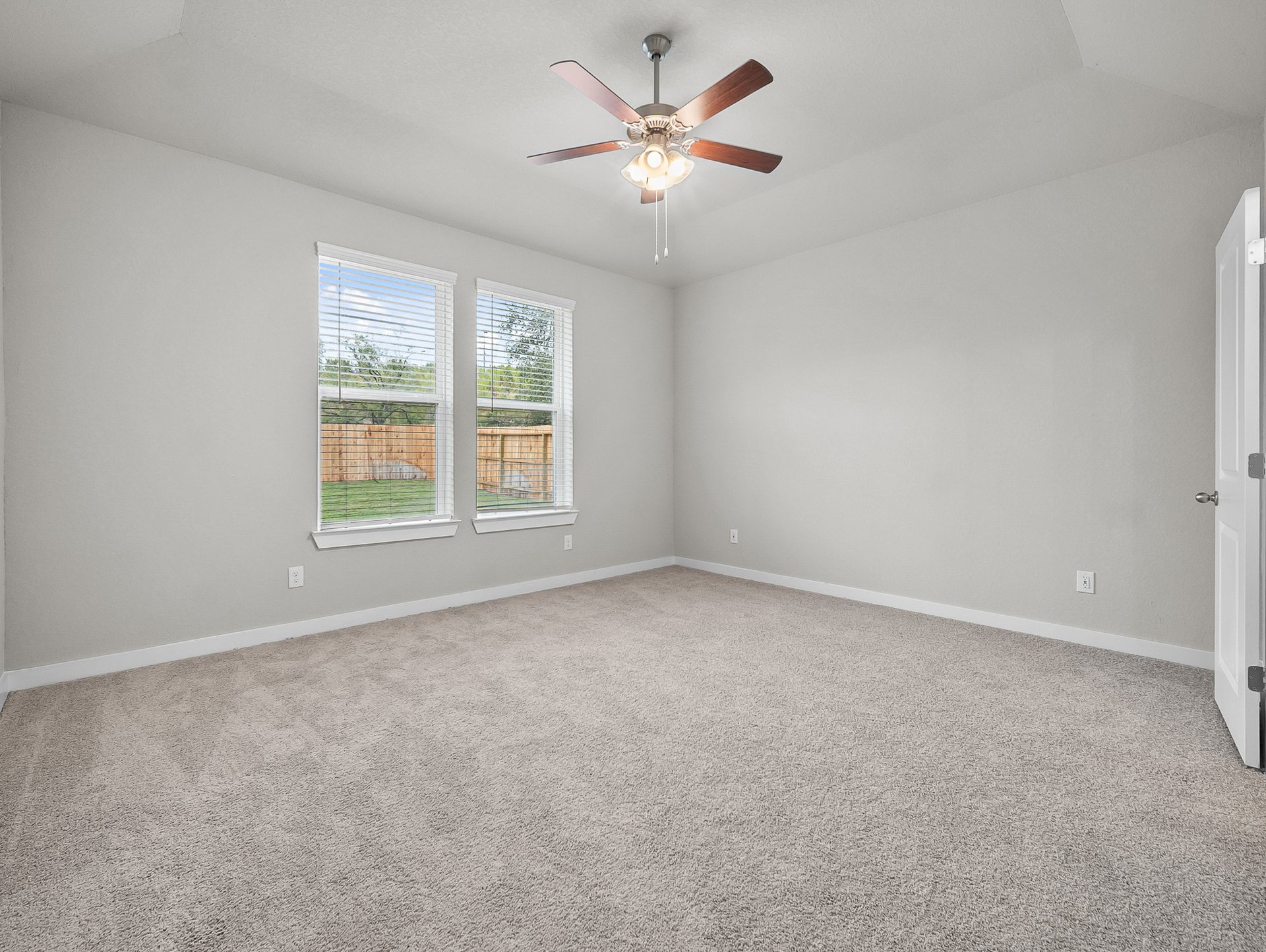 bedroom with carpet, windows & a ceiling fan