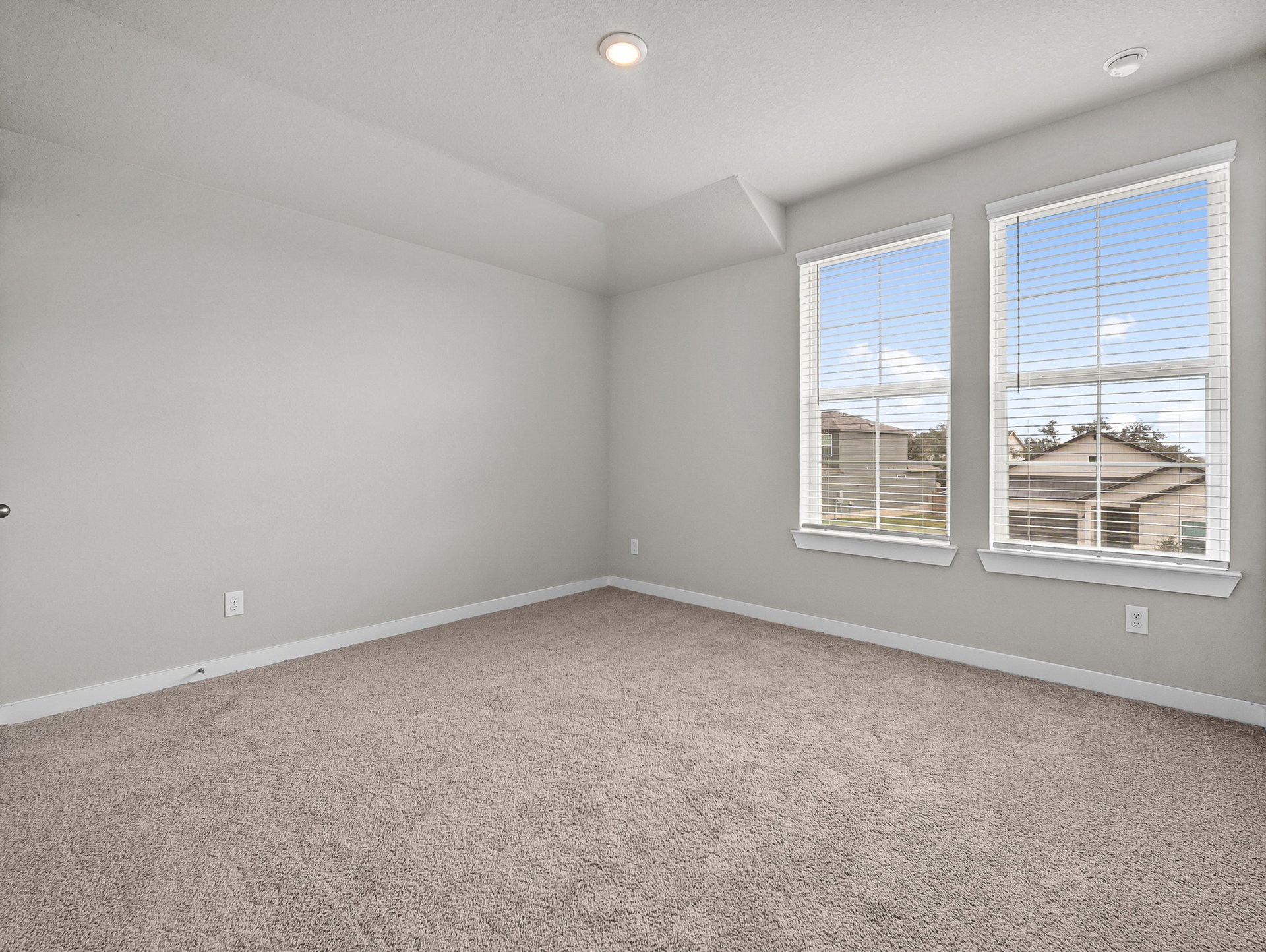 bedroom with carpet, windows & a sloped ceiling