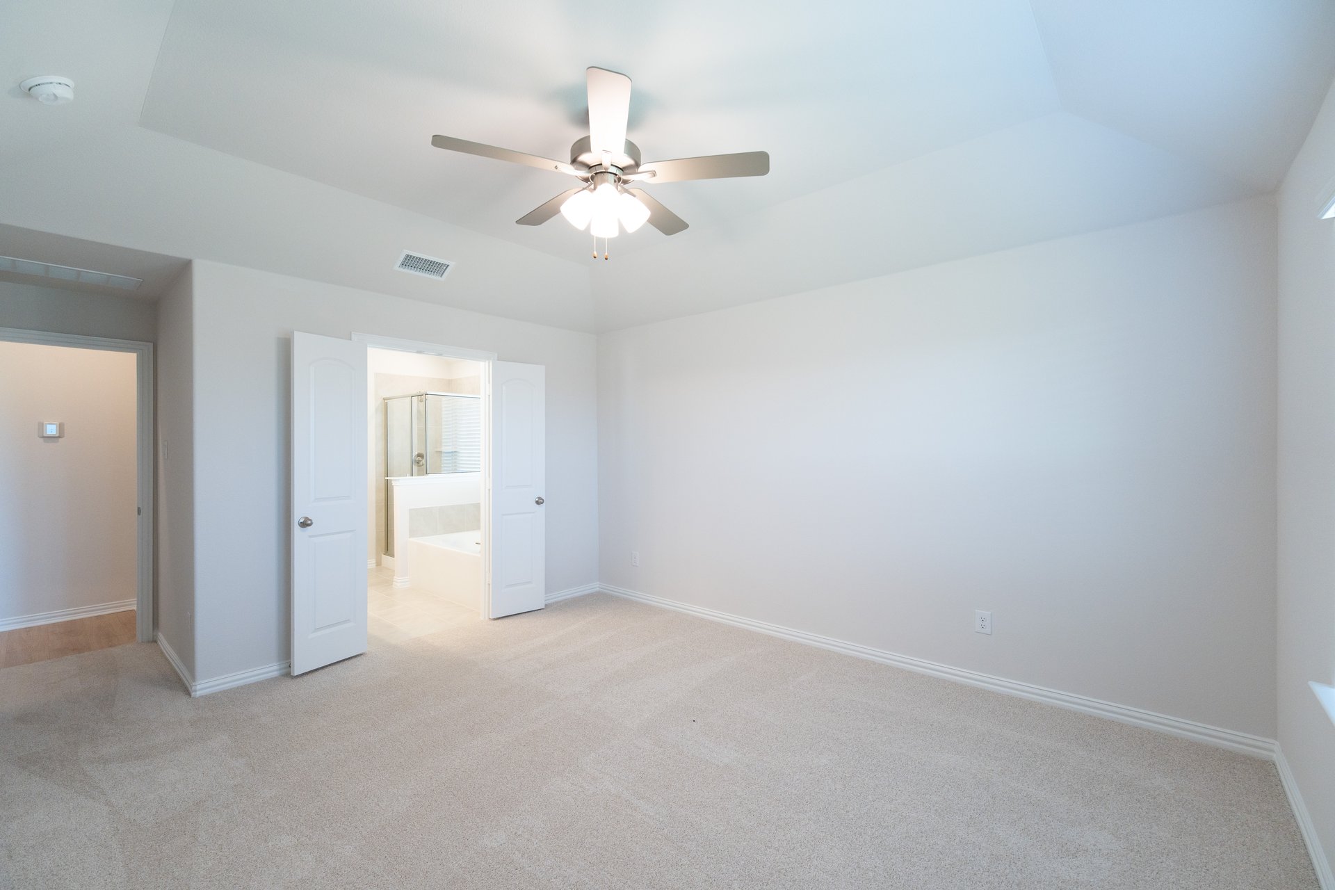 primary bedroom with carpet and ceiling fan