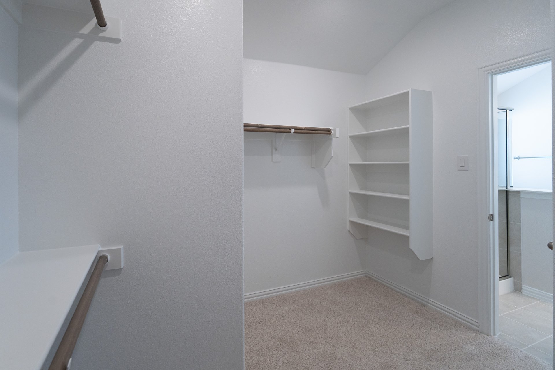 primary closet with carpet and white shelves