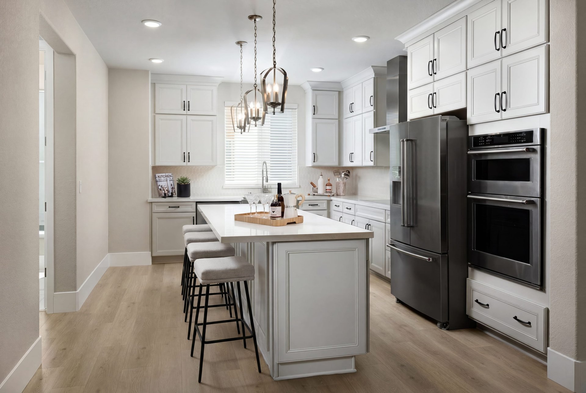 kitchen with white ceiling height cabinets, wood floors, island, and stainless steel appliances