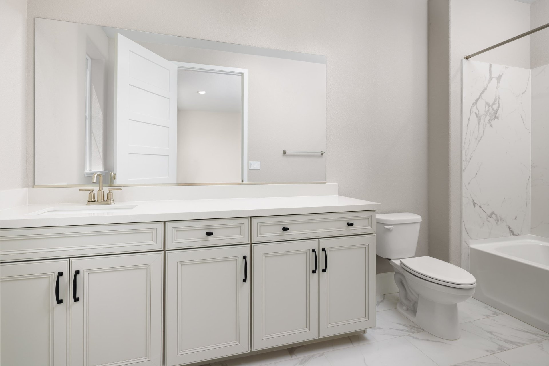 bathroom with white cabinets & counters, and tub with shower over head