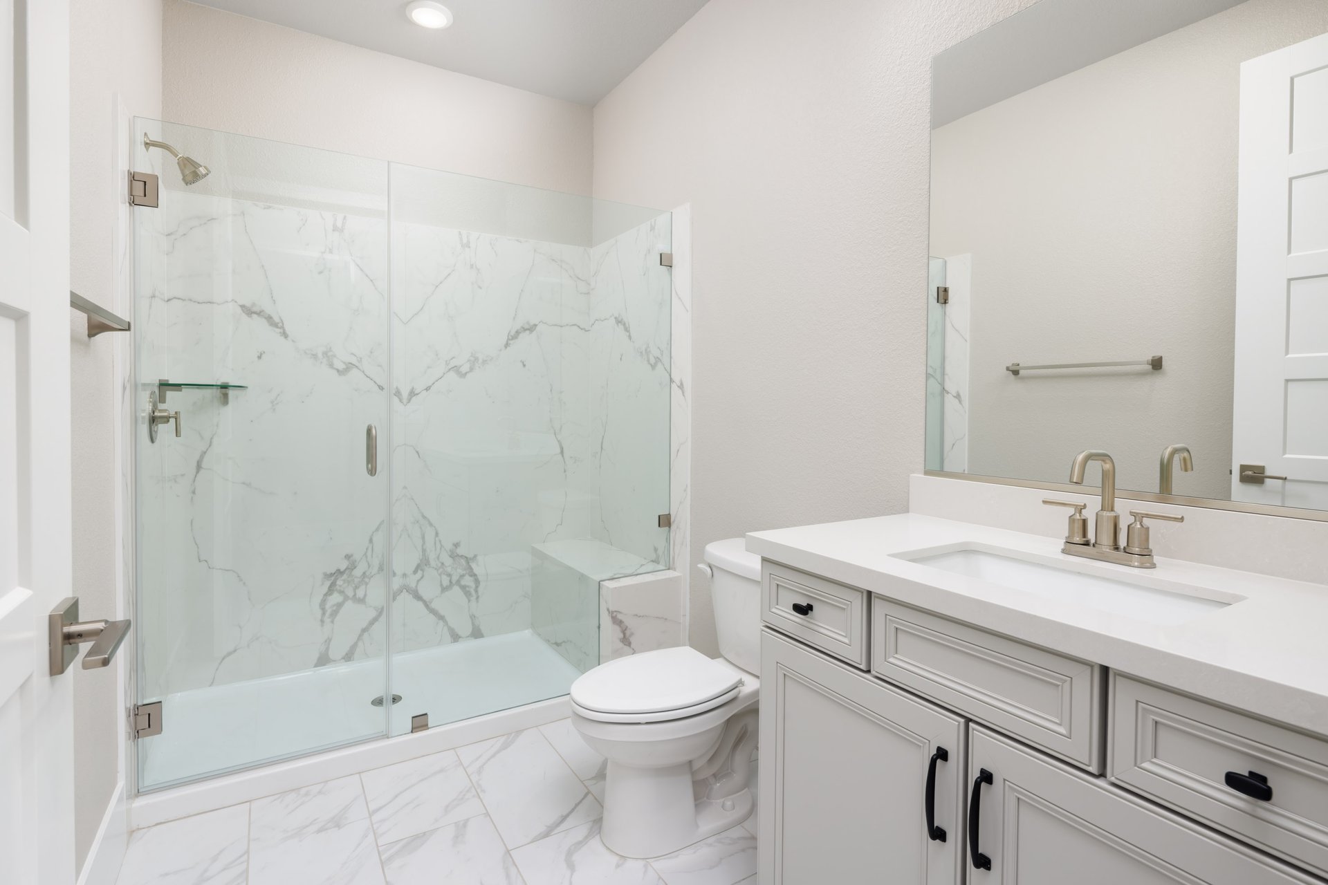 bathroom with white cabinets & counters, and large walk-in shower with seat and glass enclosure