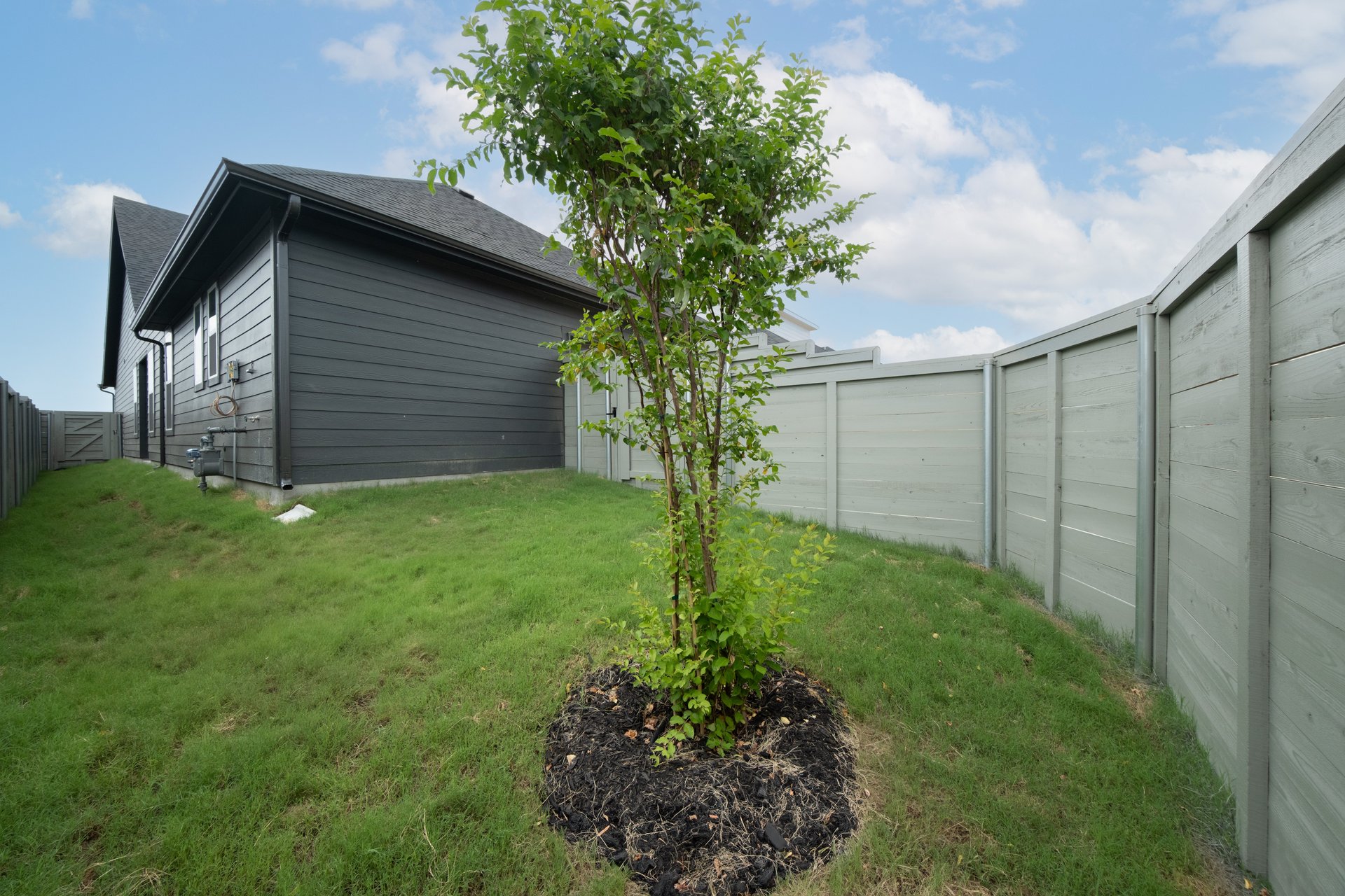 backyard of home with grass and fence