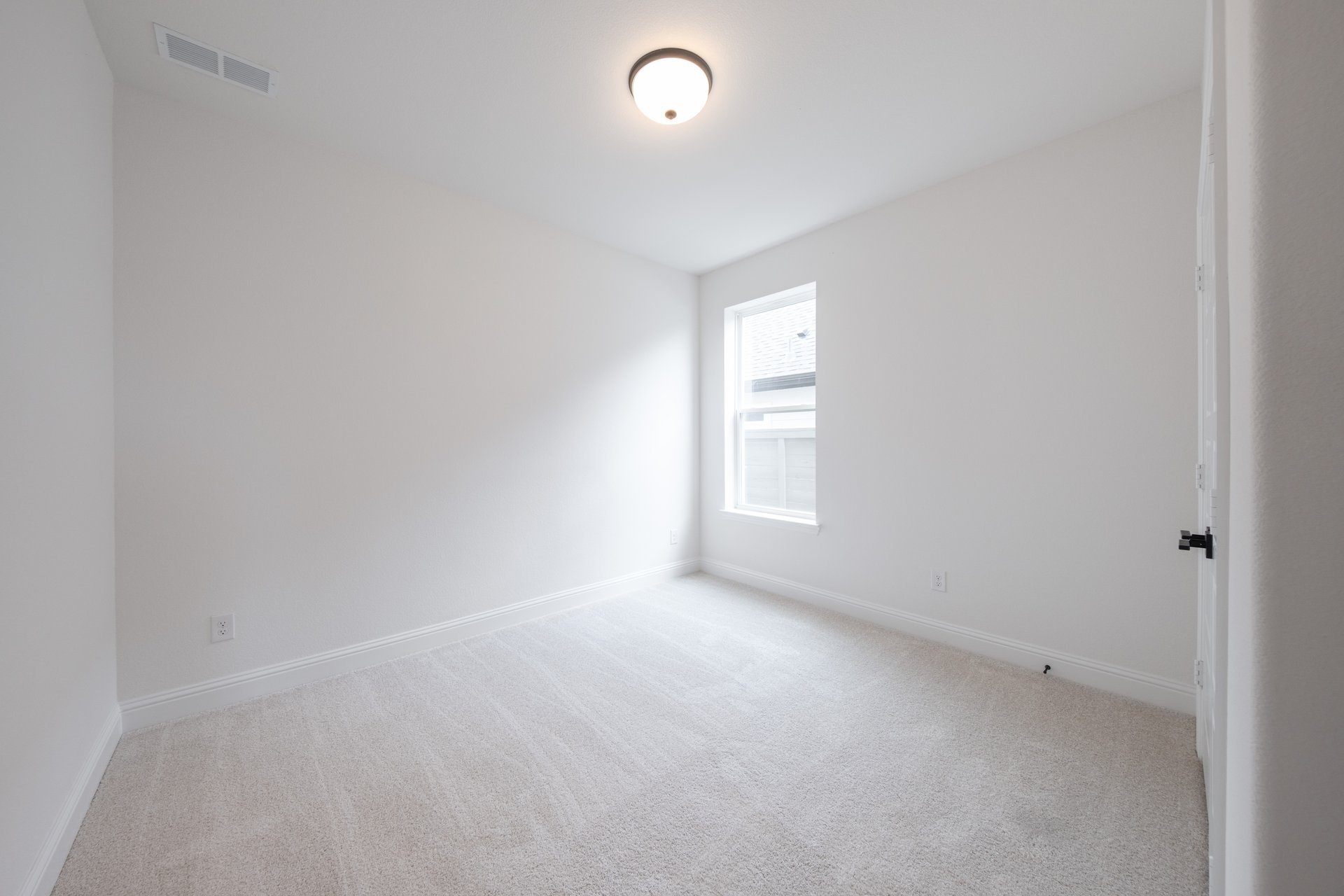 guest bedroom with carpet and window