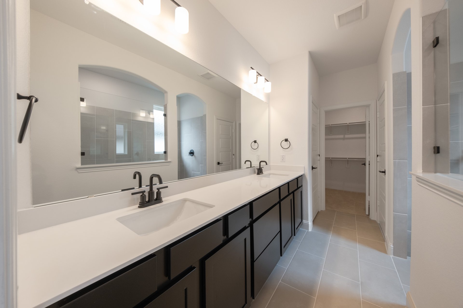 primary bathroom with double sinks and tile flooring