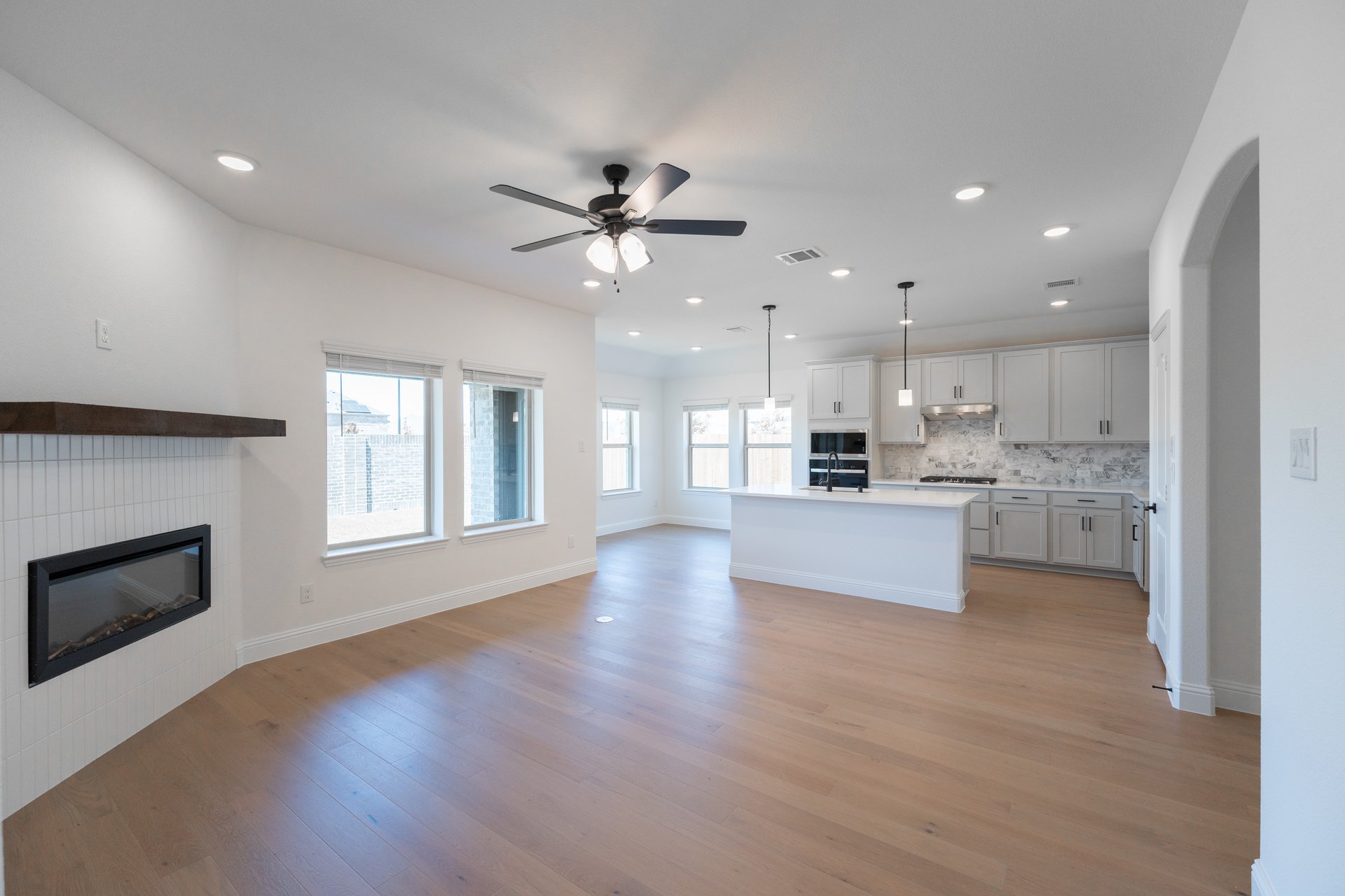 open great room with wood floors and fireplace