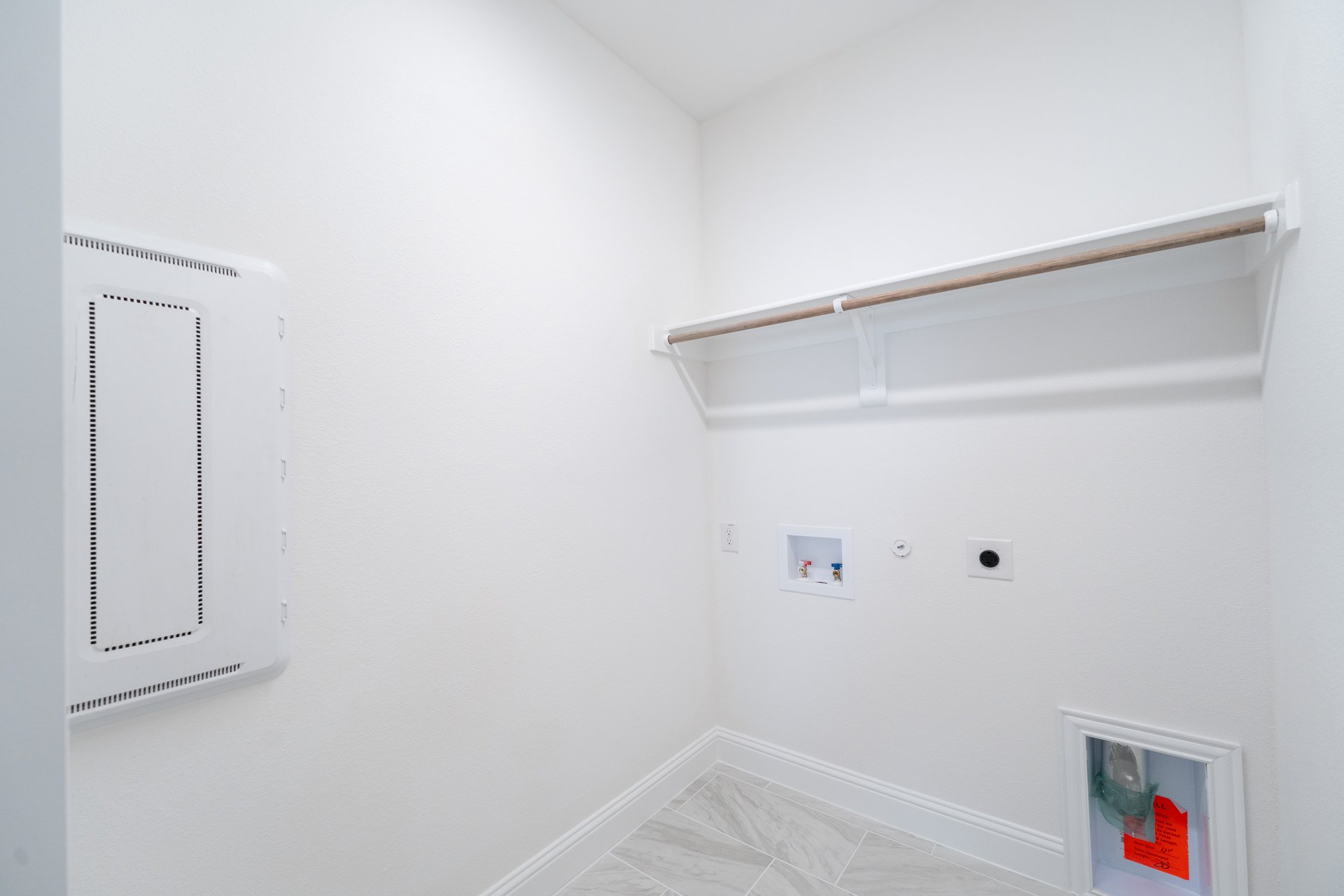 laundry room with tile floors and white shelf