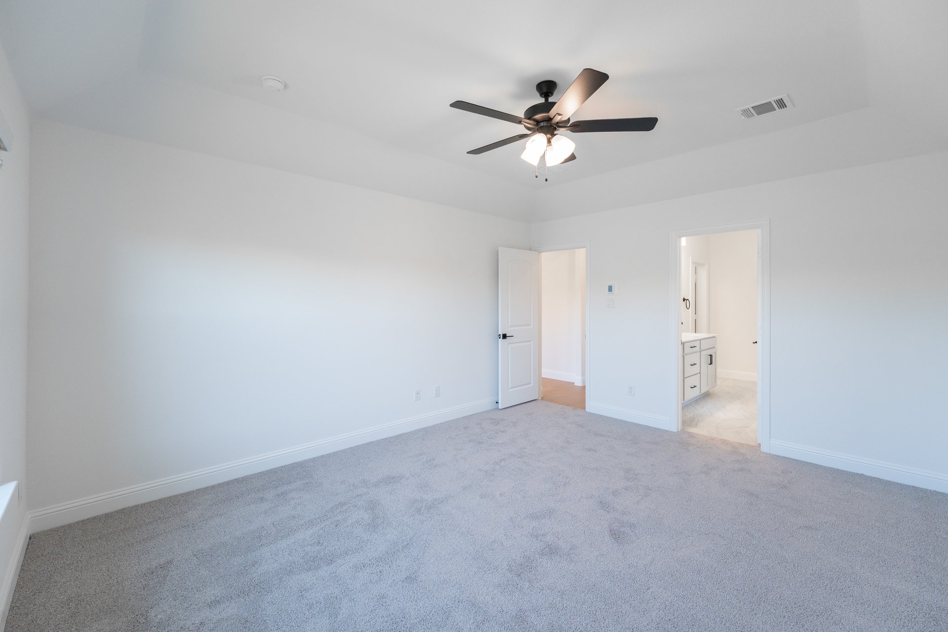 primary bedroom with carpet and ceiling fan