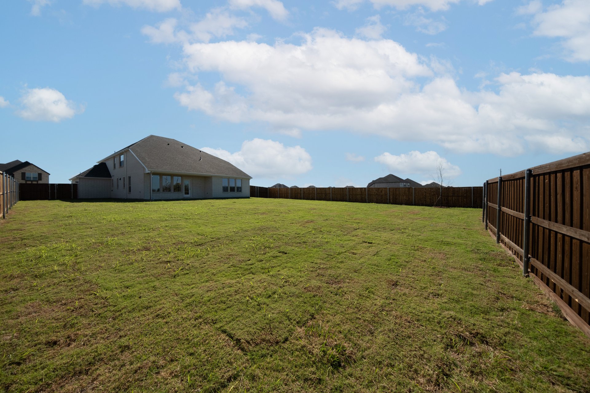 large backyard with wood fence and grass