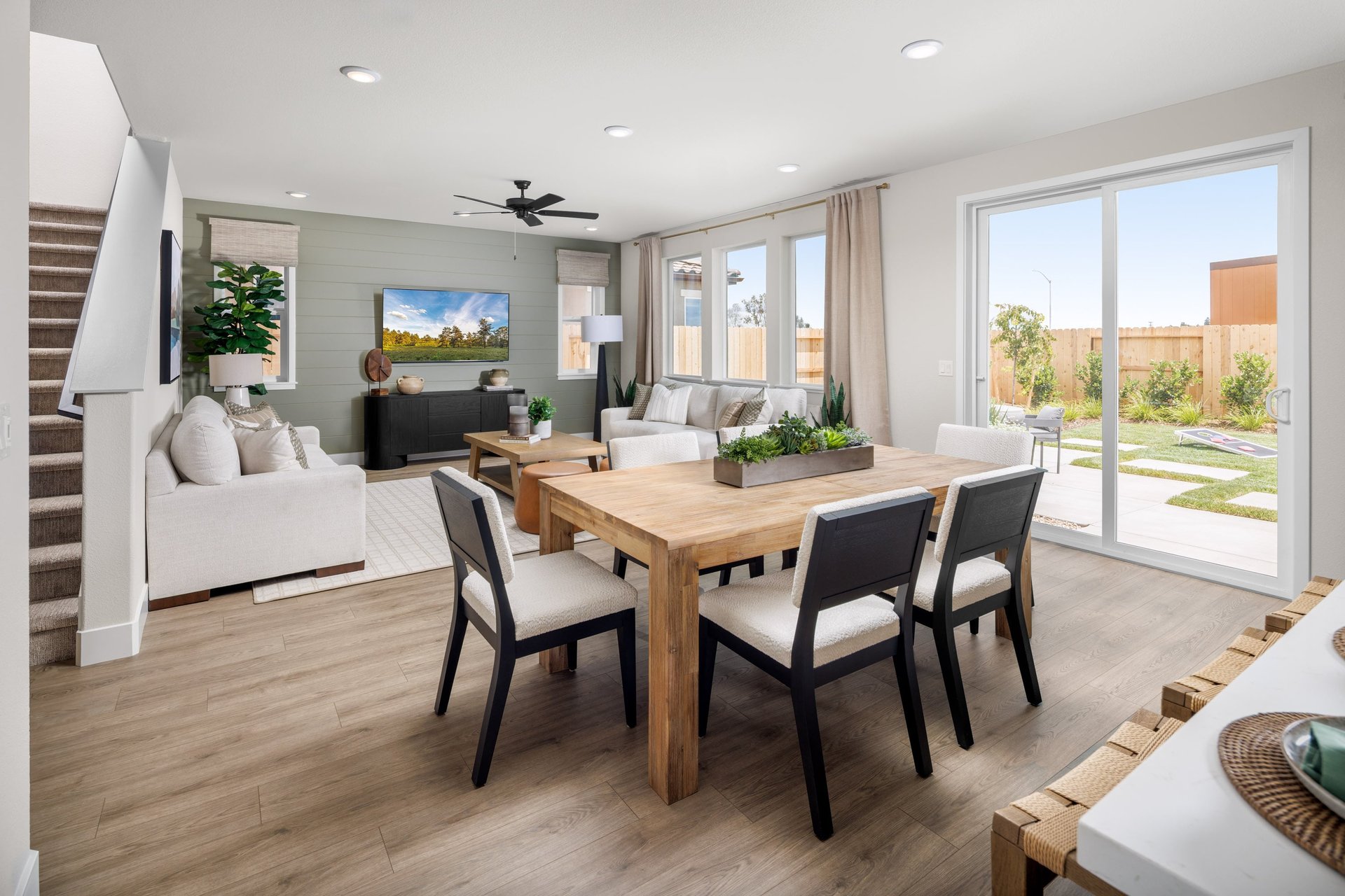 dining room with wood floors, wood table with six chairs, and sliding glass door to the backyard