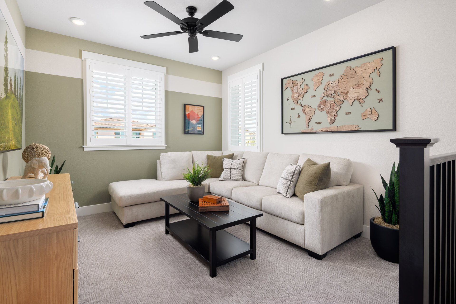 loft with green wall, white sofa, windows, and black coffee table